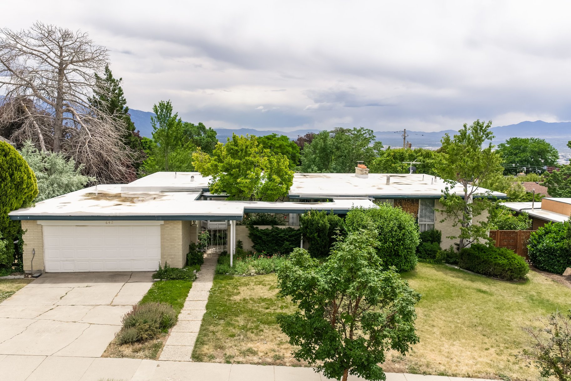 Mid-century style residence featuring a flat roofline and integrated garage
