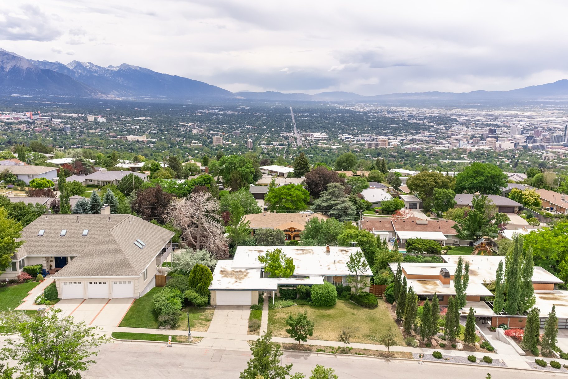 Expansive neighborhood setting featuring a mountainous backdrop and distant city skyline
