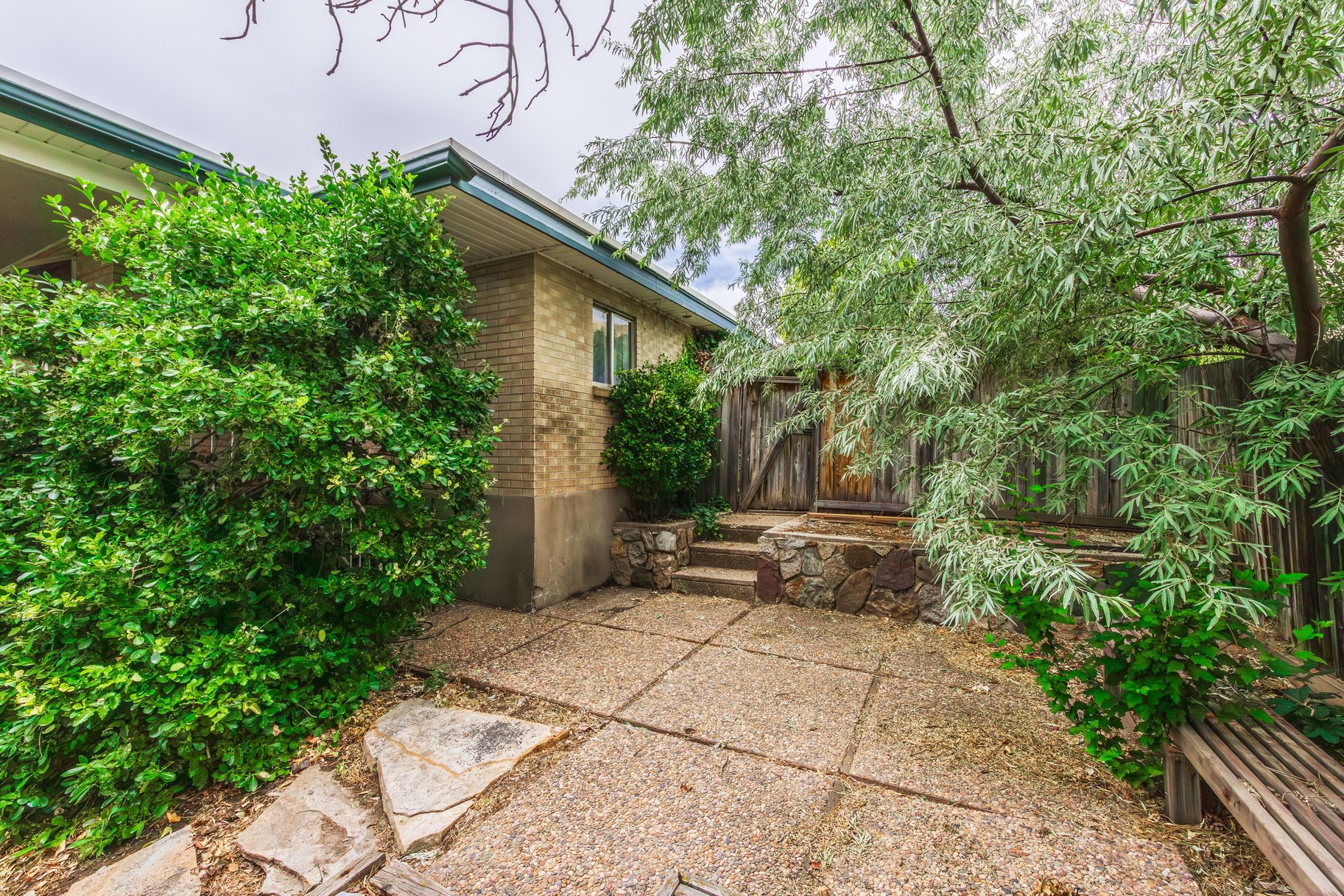 Exterior pathway featuring concrete pavers and natural stone accents