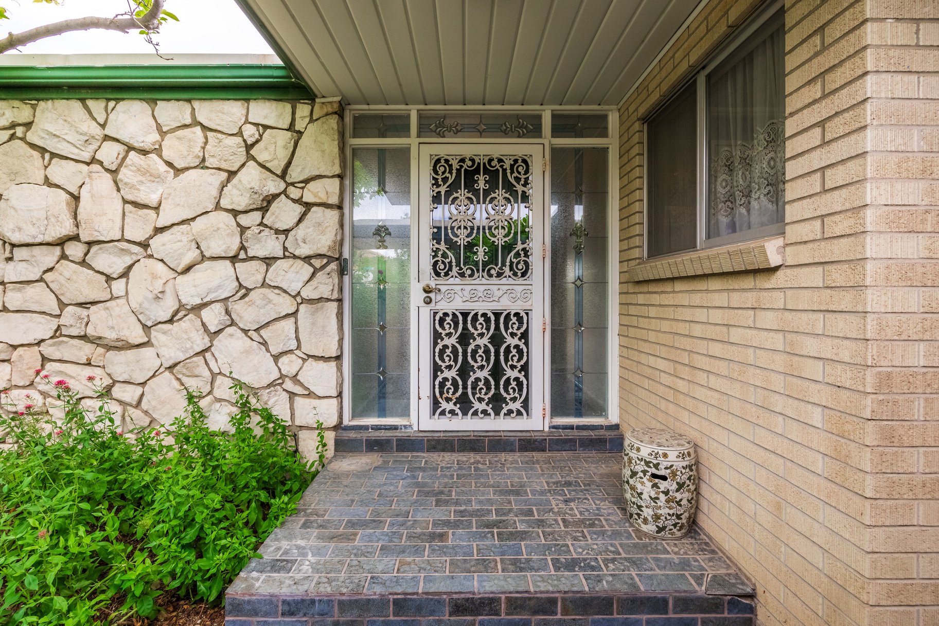 Entryway featuring a decorative security door, sidelight windows, and stone veneer accent wall