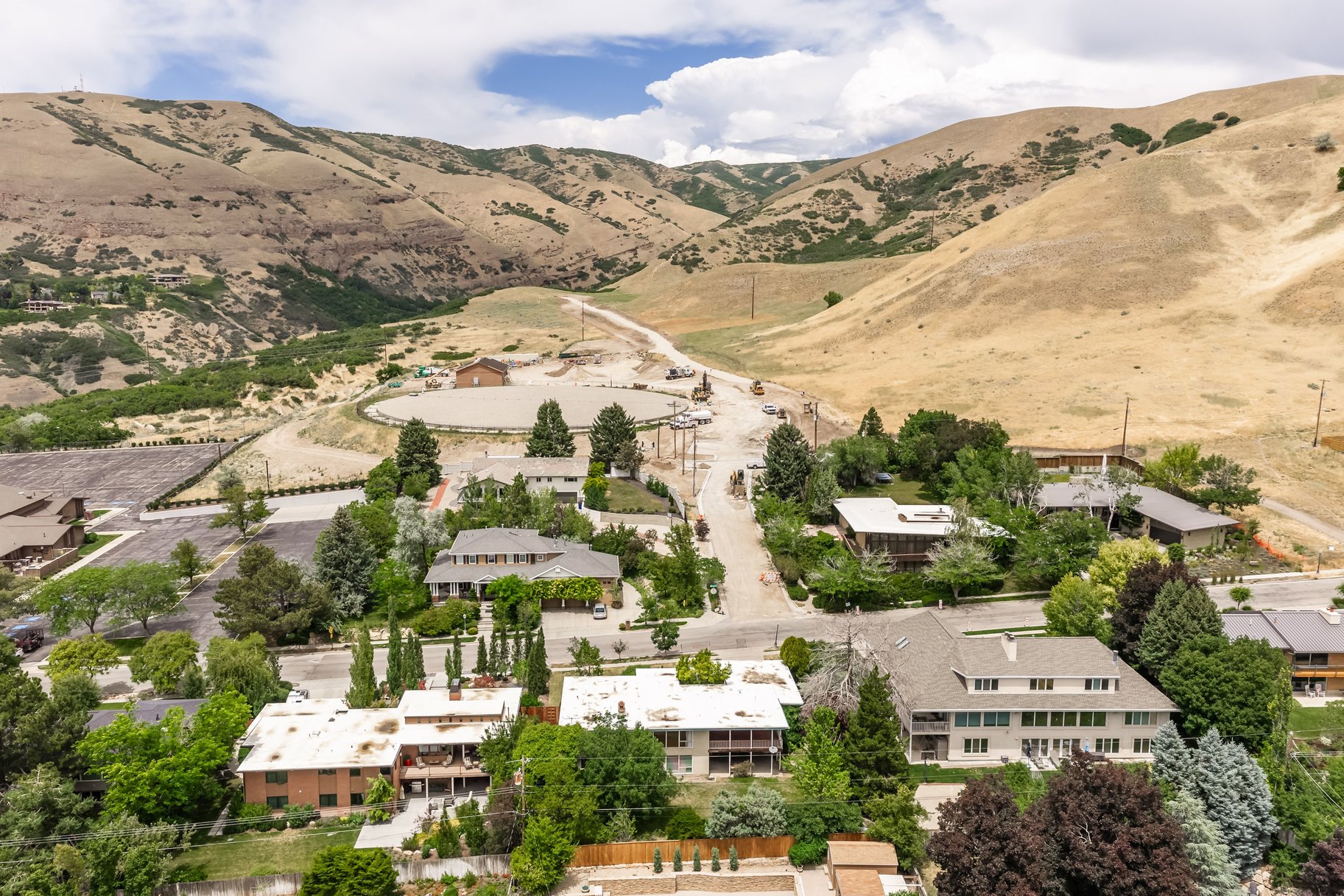 Aerial perspective showcasing a residential community nestled at the base of expansive, arid hills