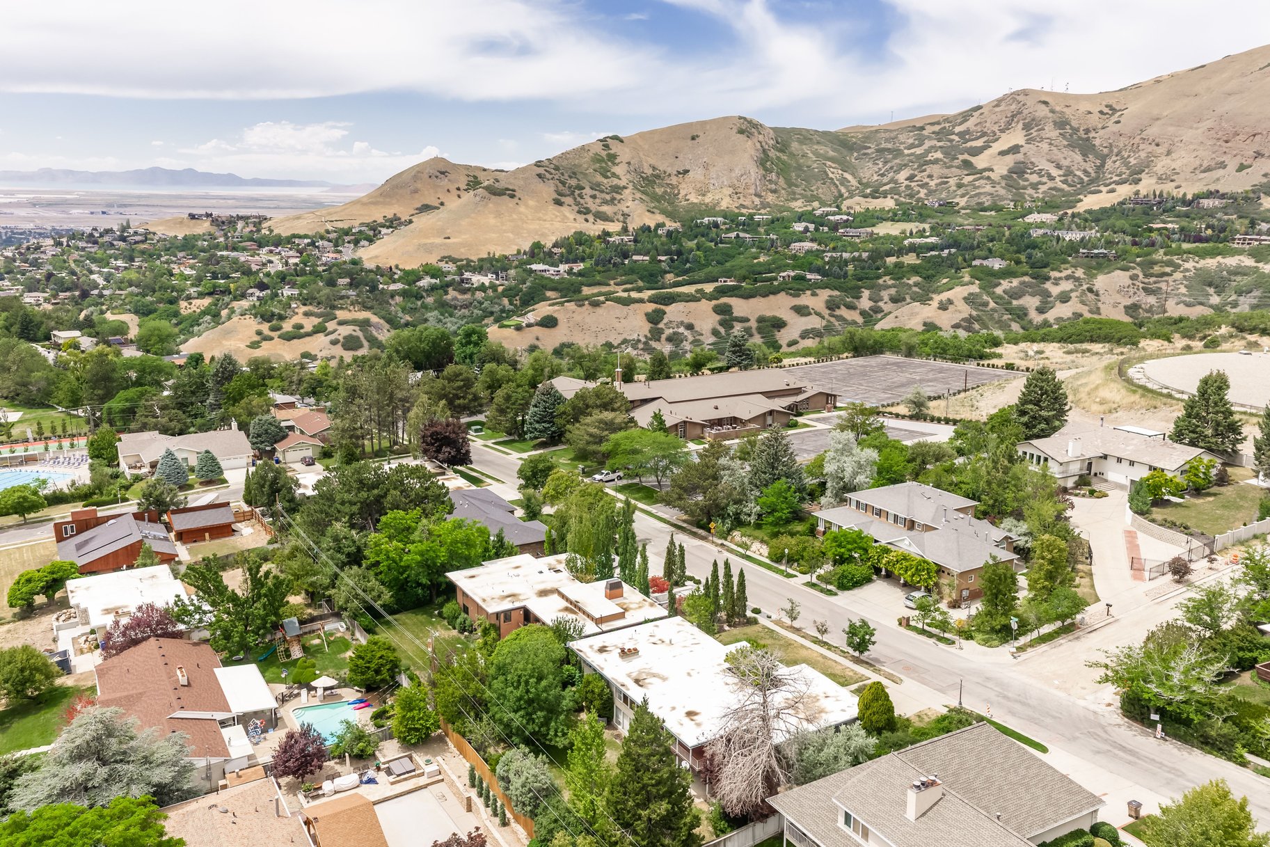 Expansive aerial view showcasing a neighborhood nestled against a mountainous backdrop