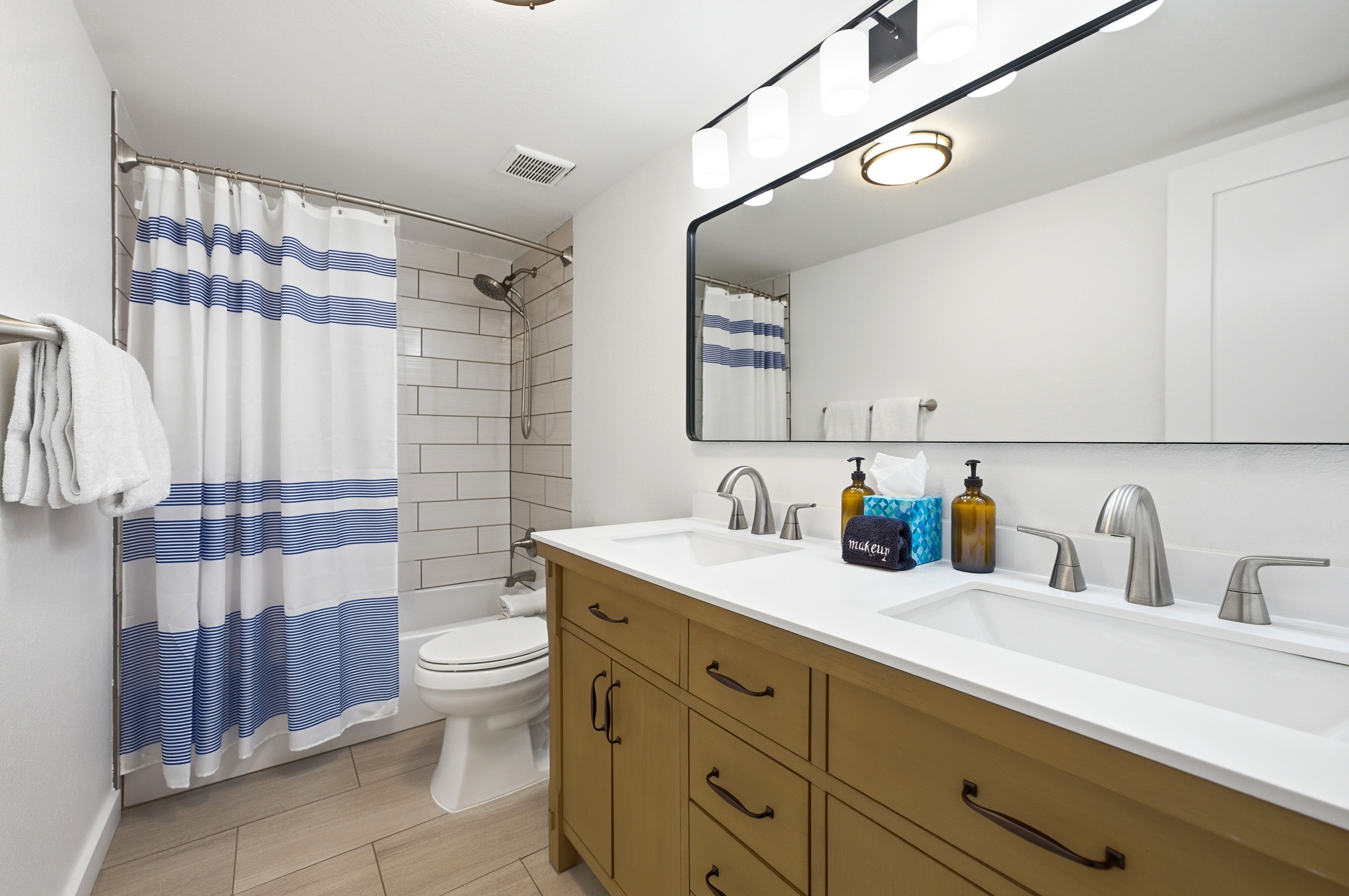 Double vanity with integrated sinks, brushed nickel fixtures, and a large framed mirror