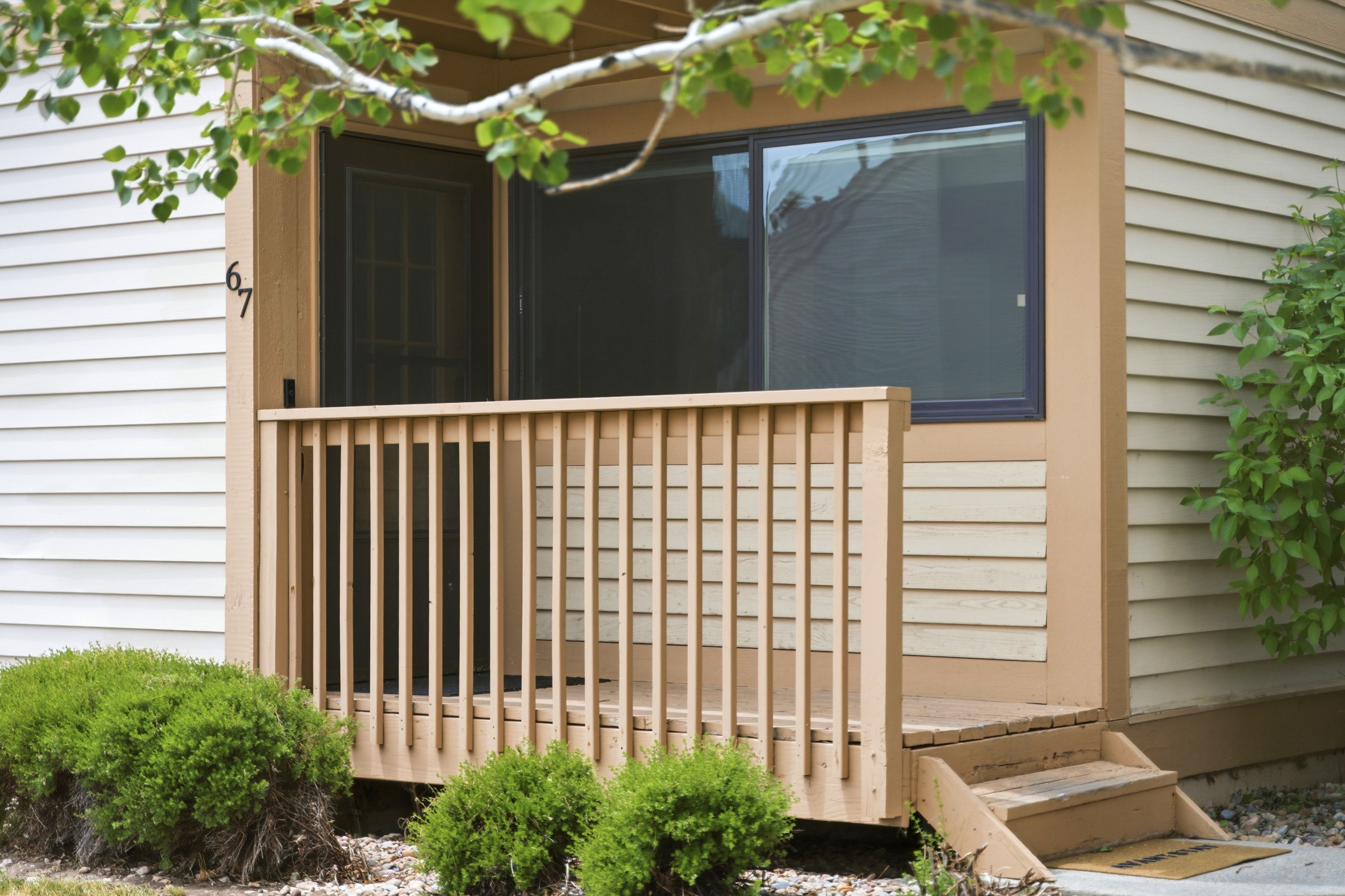Front entry featuring a private wooden deck with baluster railing