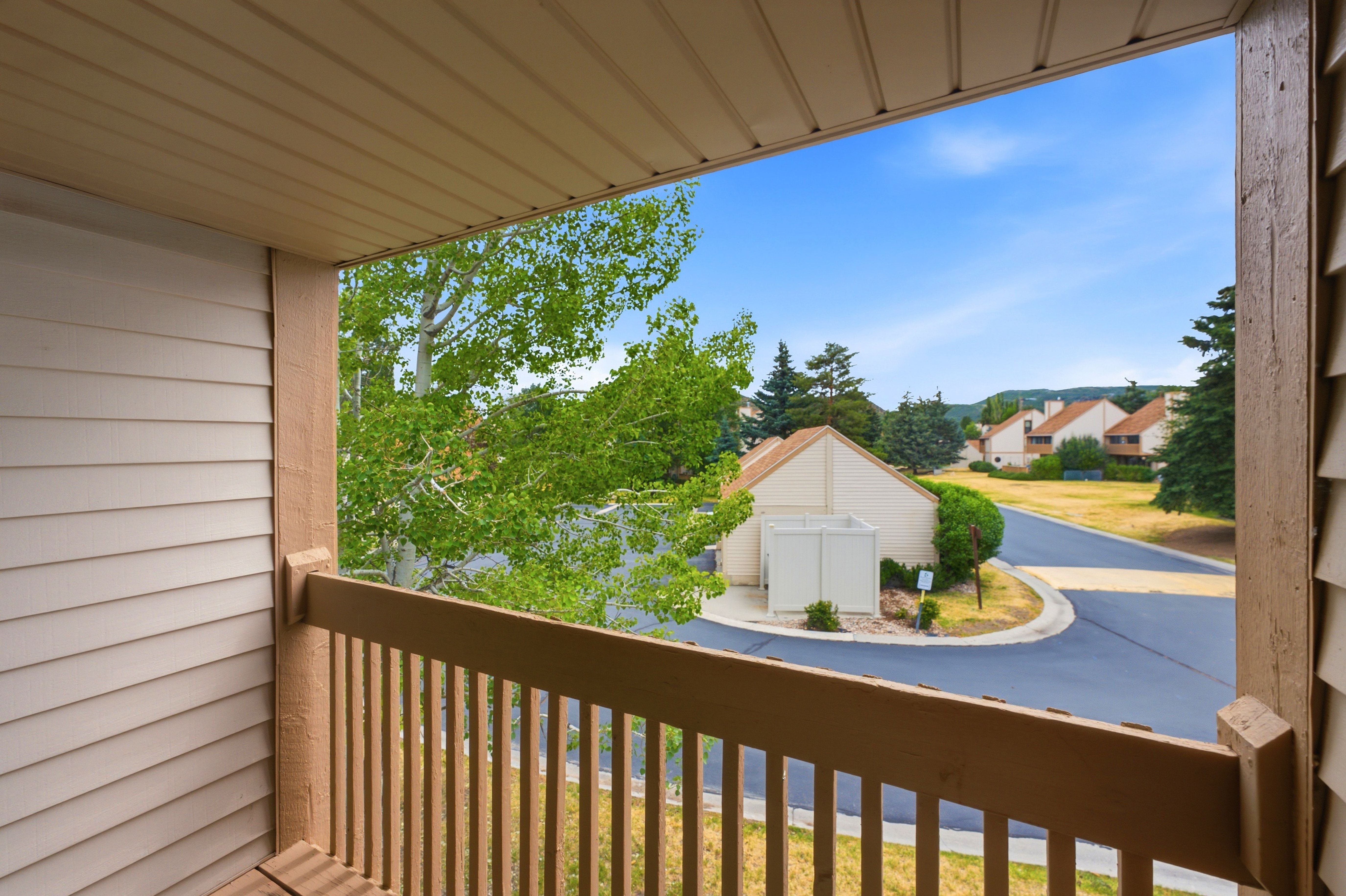Private balcony with a wooden railing and a slatted ceiling, offering expansive outdoor space