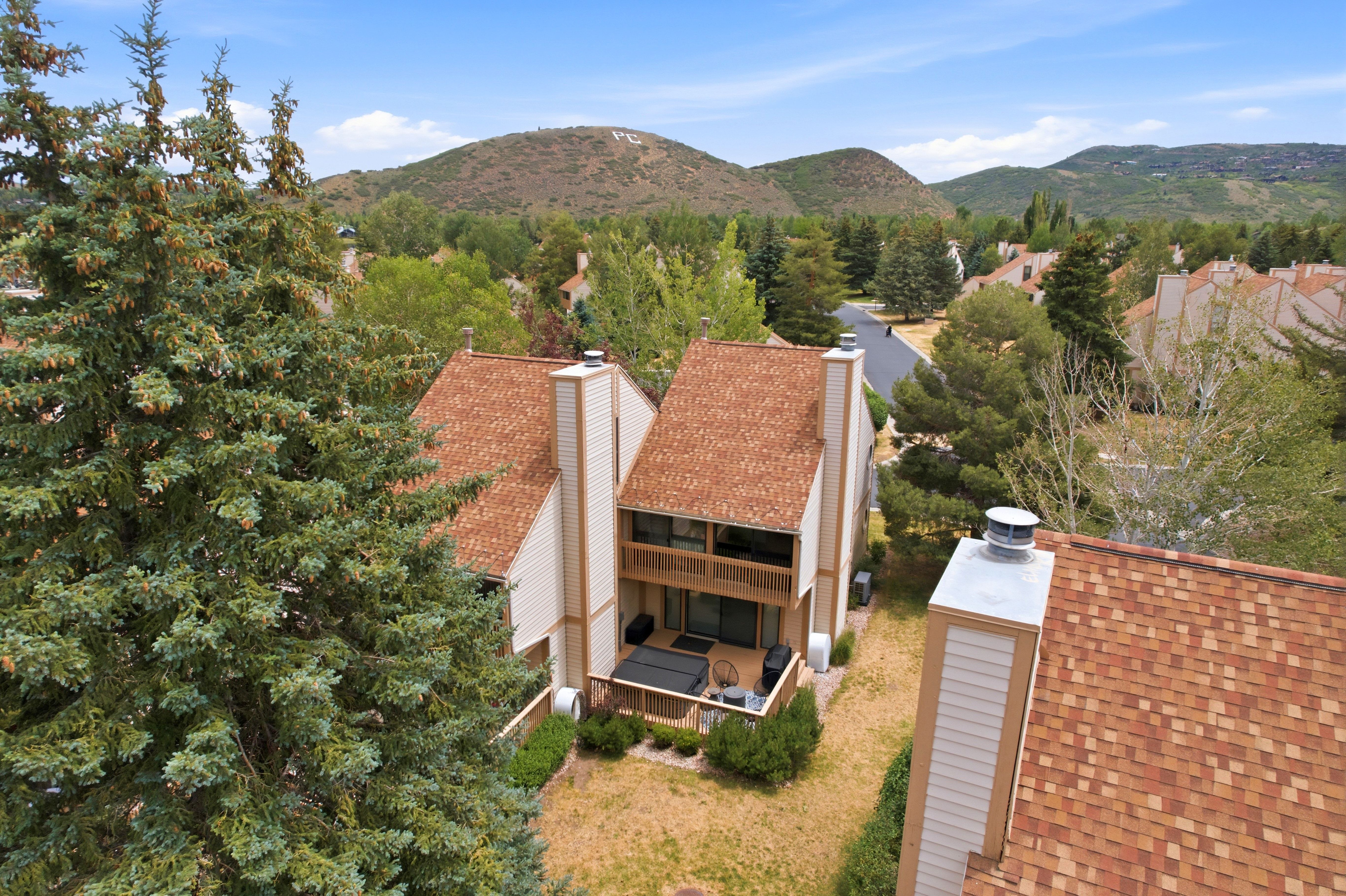 Two-story residences with complementary light-colored siding and brown shingle roofs