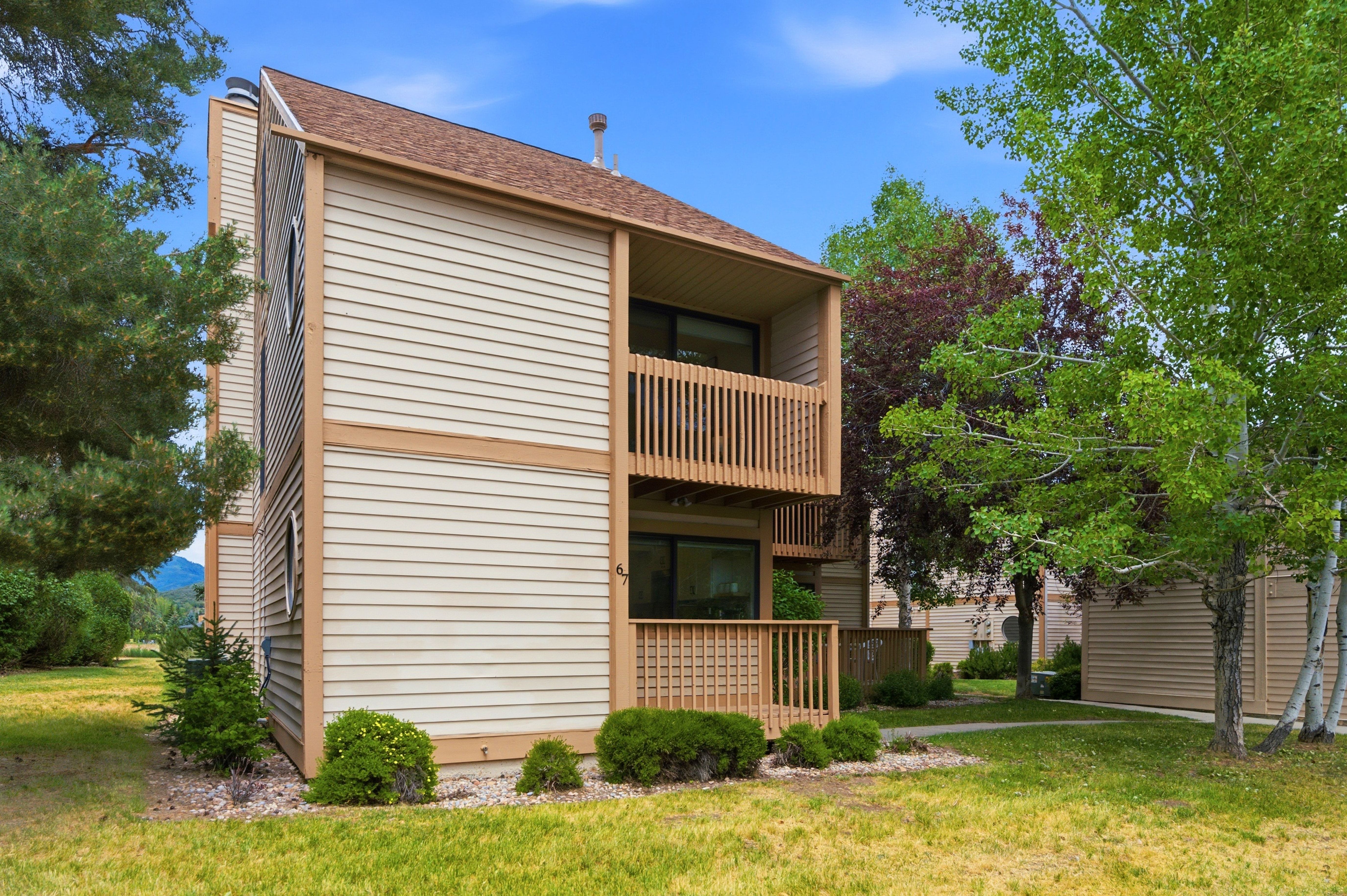 Multi-story exterior with horizontal siding and a visible brown shingle roof
