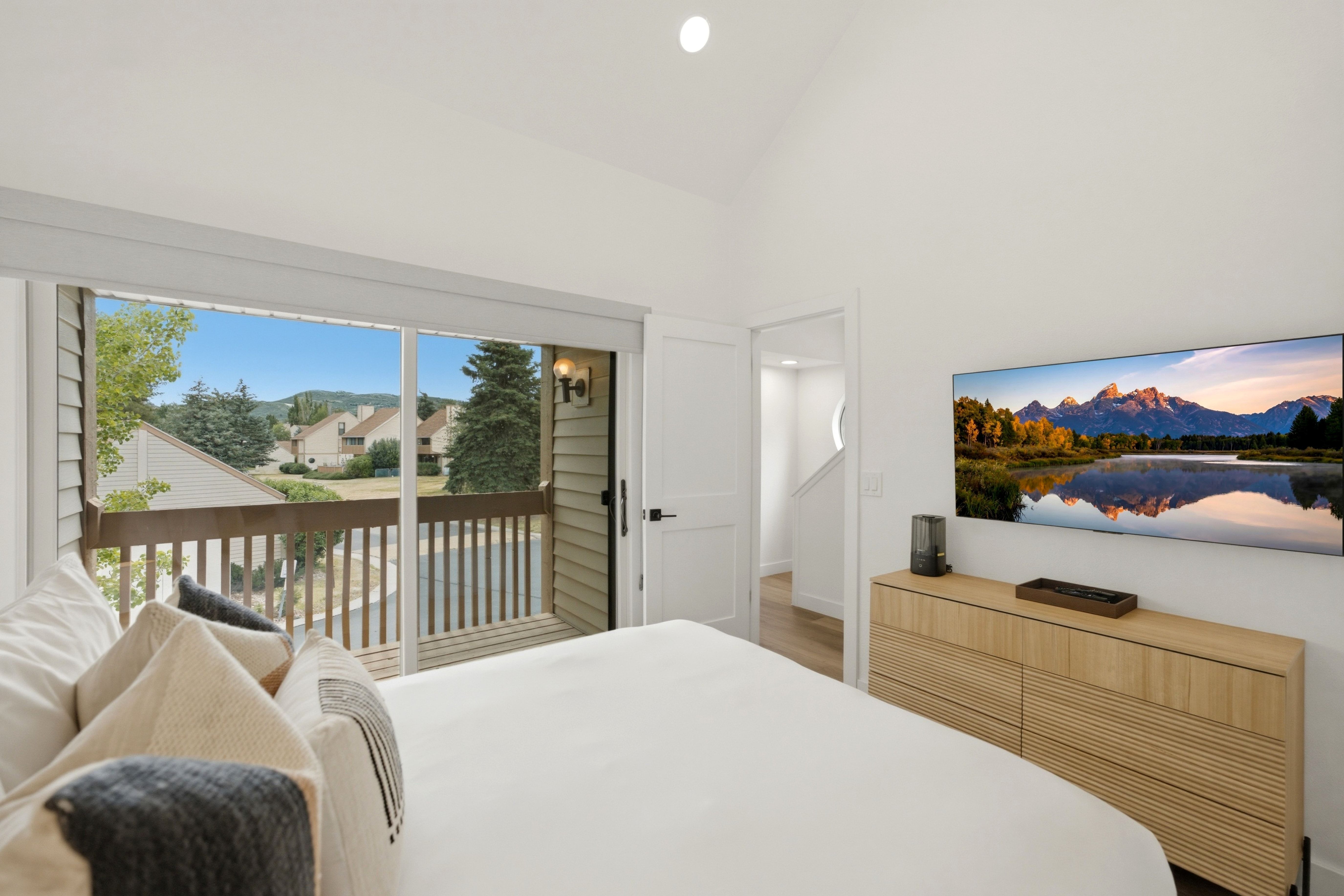Room featuring vaulted ceilings and a private balcony with wood railing