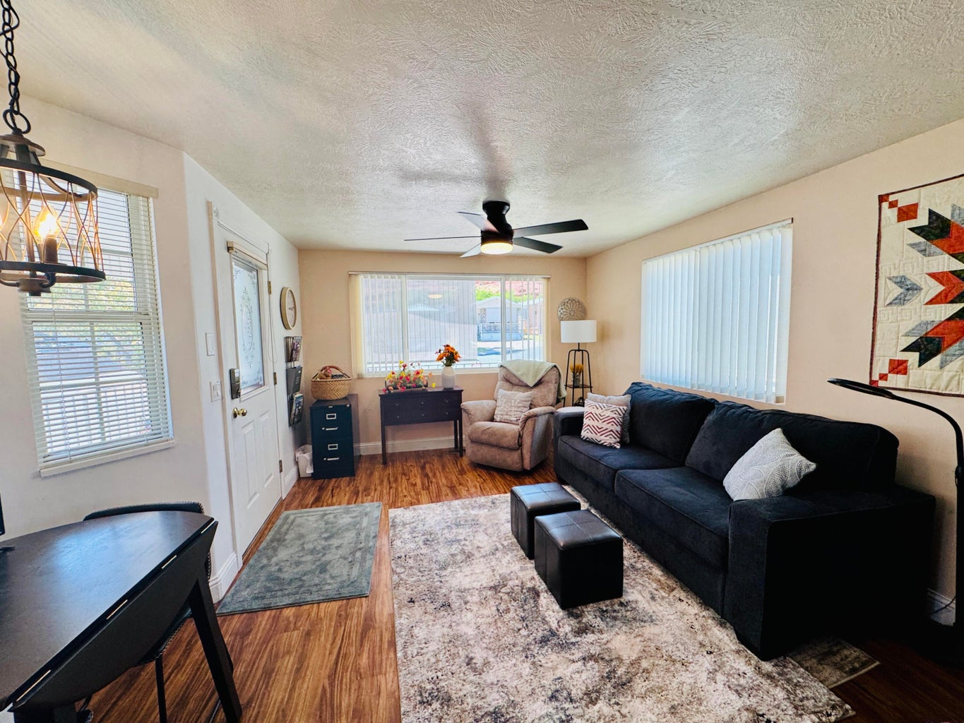 Living area with wood-finish flooring and a ceiling fan
