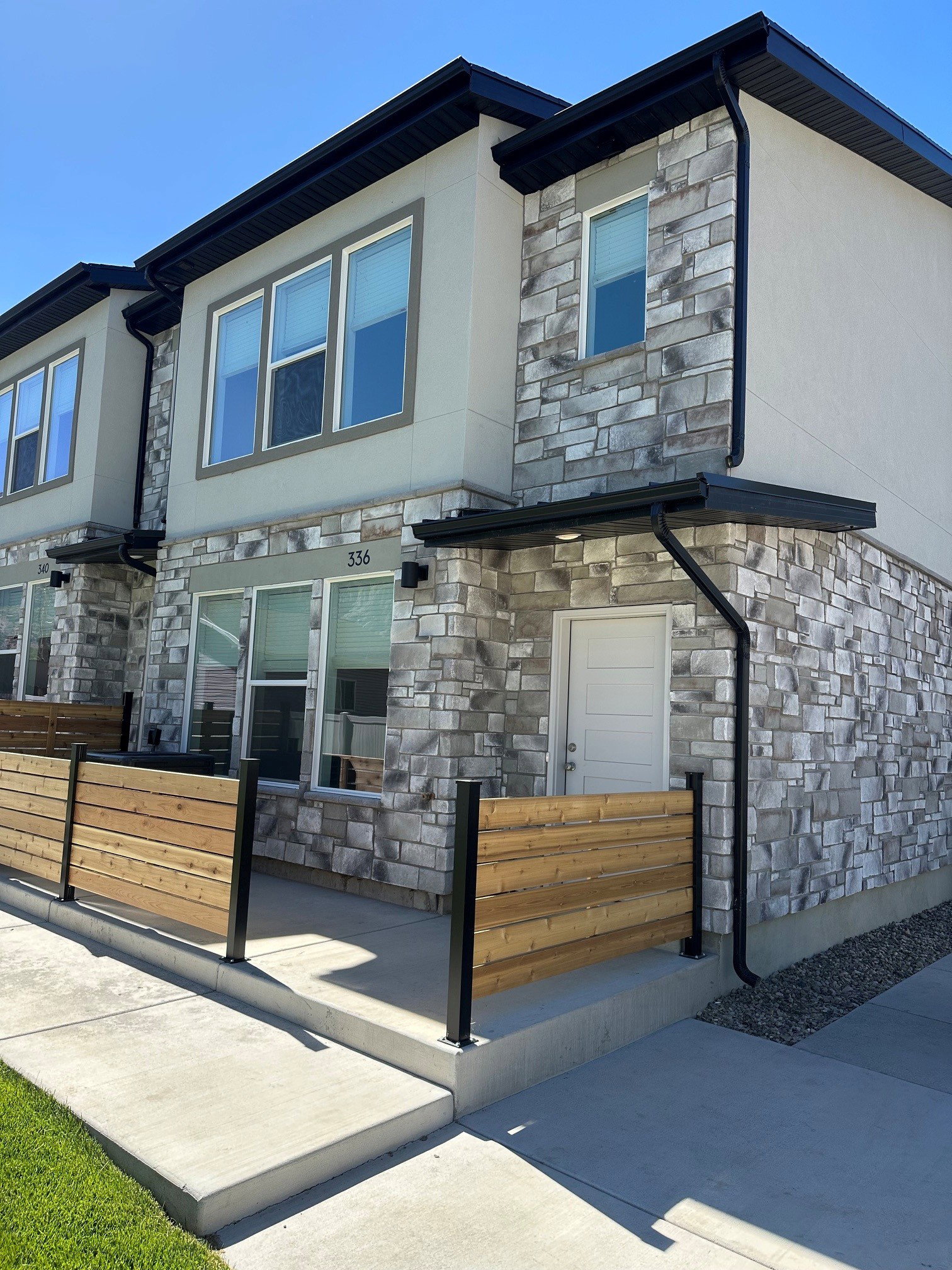 Modern multi-level exterior with stone veneer and stucco siding