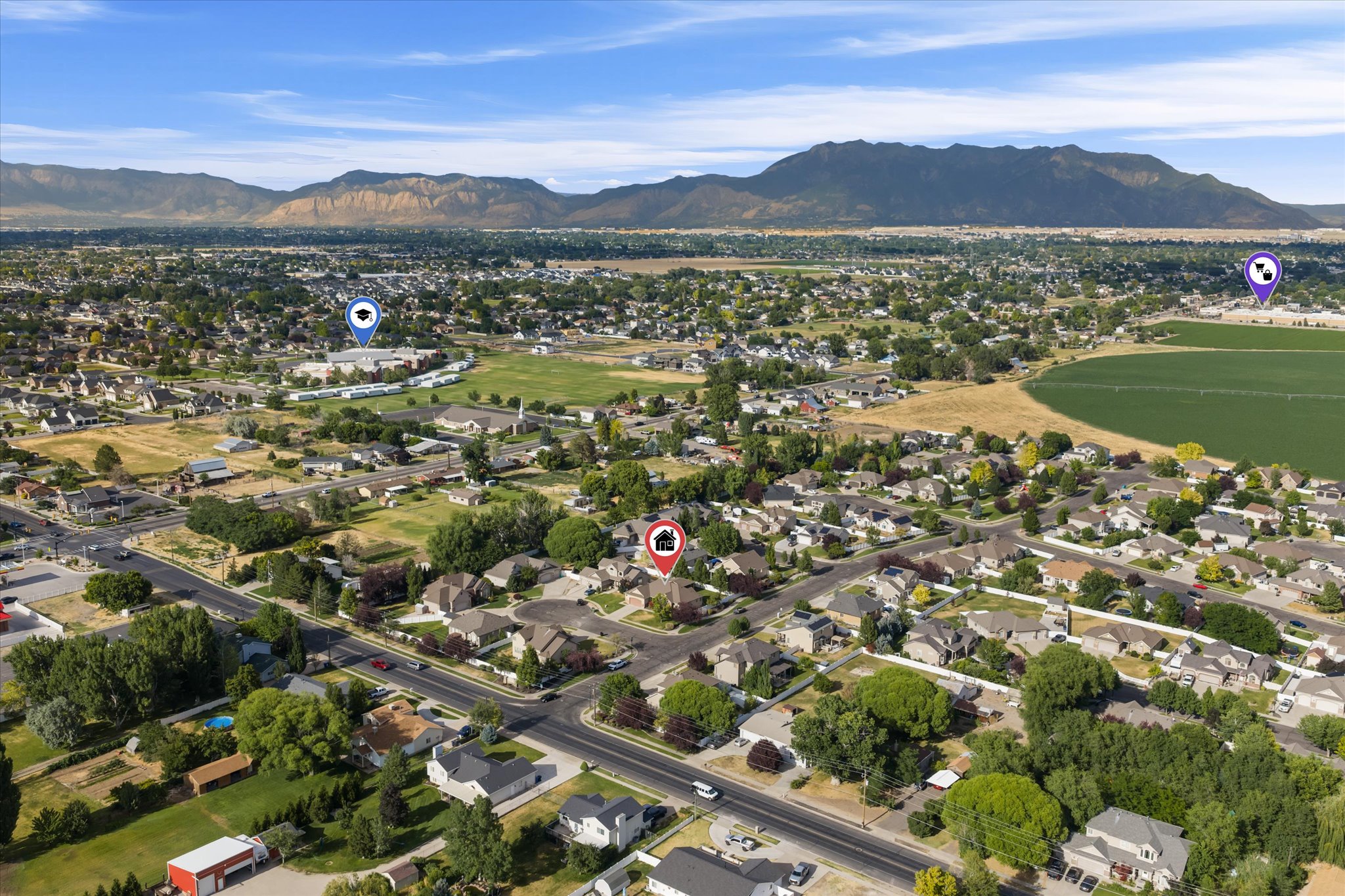 Expansive residential neighborhood featuring a mix of housing styles, mature trees, and wide streets, all set against a backdrop of distant mountains