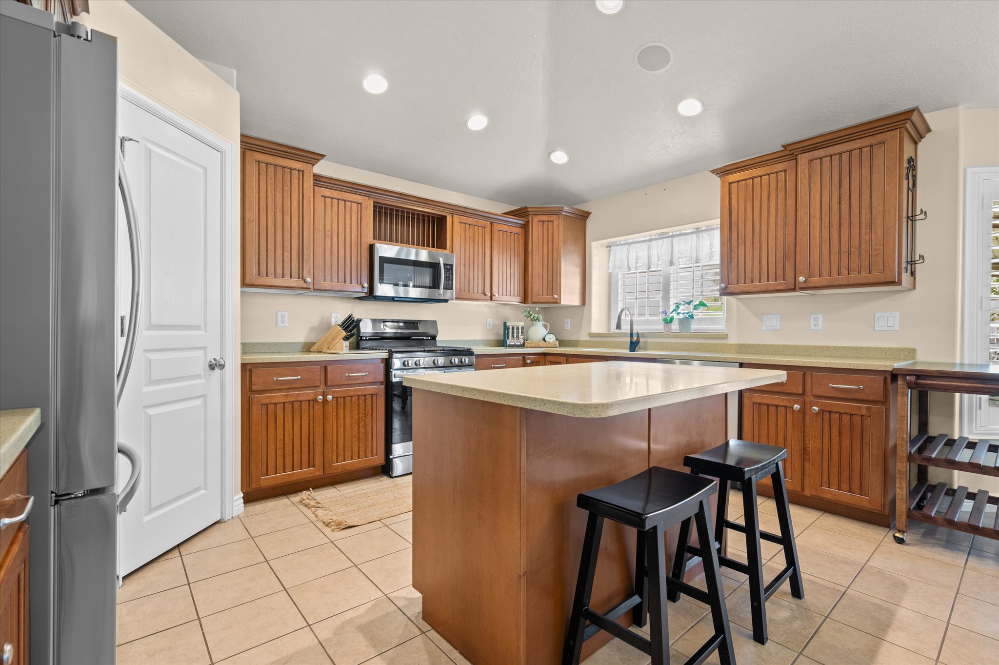Kitchen featuring wood cabinetry, light countertops, and tile flooring