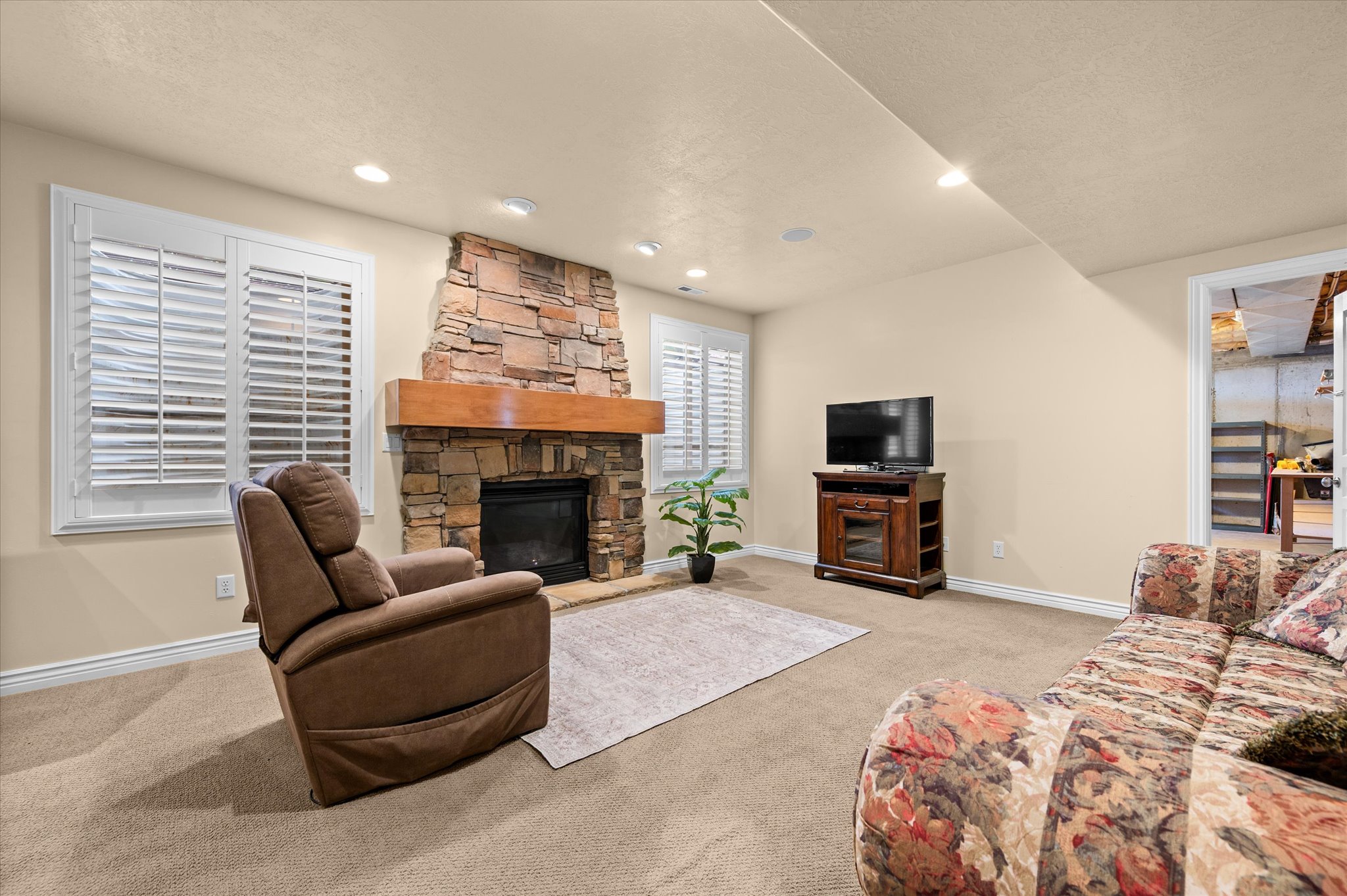 Stone-clad fireplace featuring a wood mantle