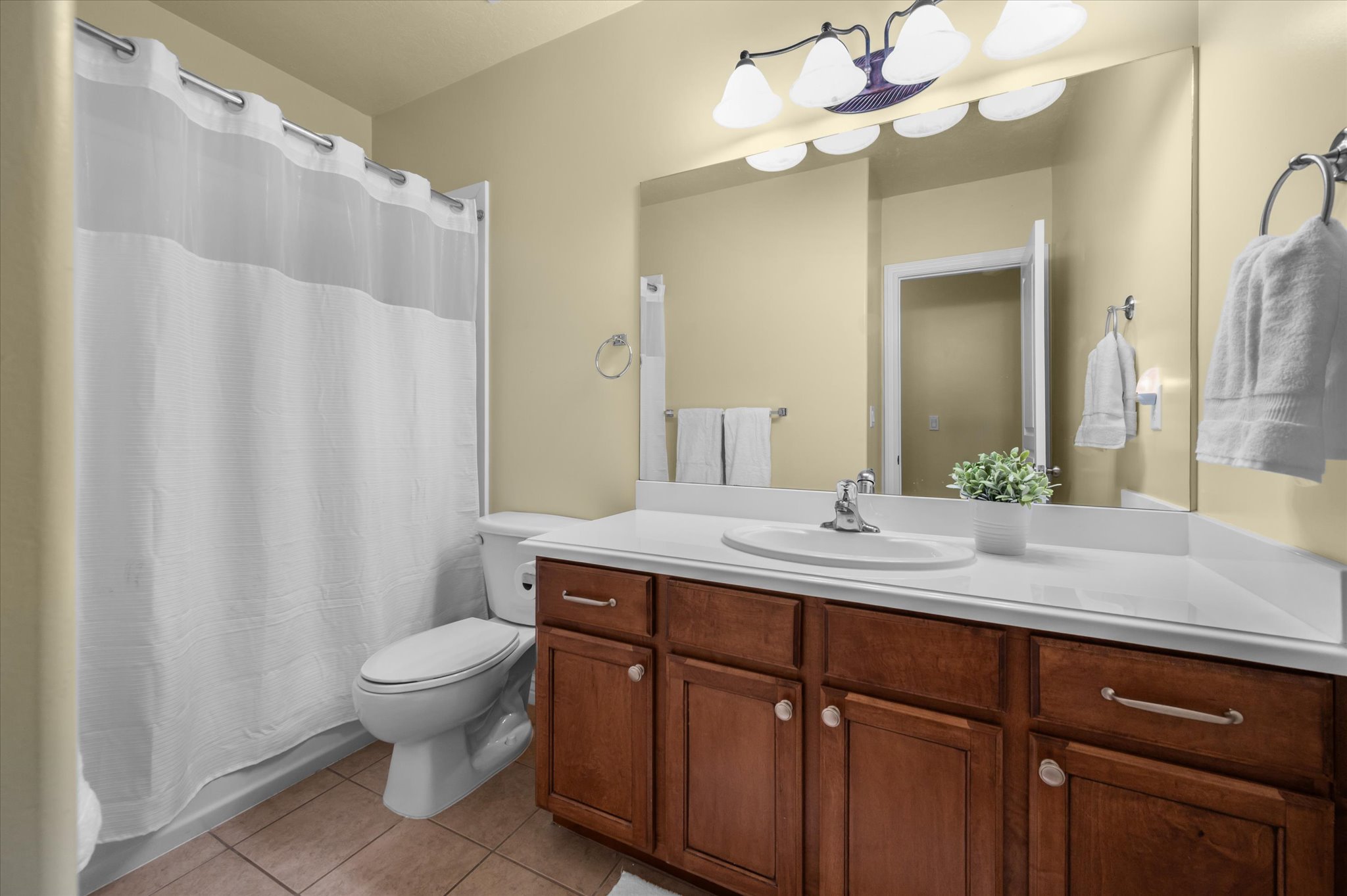 Full vanity featuring a white countertop, integrated sink, and wood-finish cabinetry