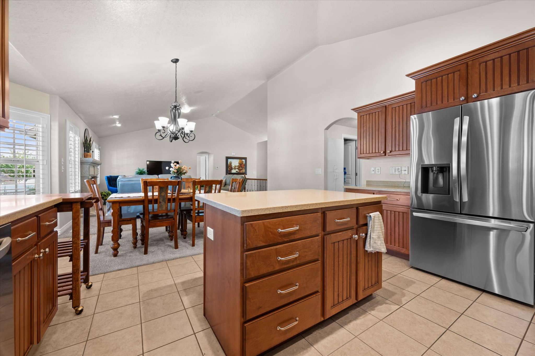 Kitchen featuring wood cabinetry, stainless steel refrigerator, and tiled flooring