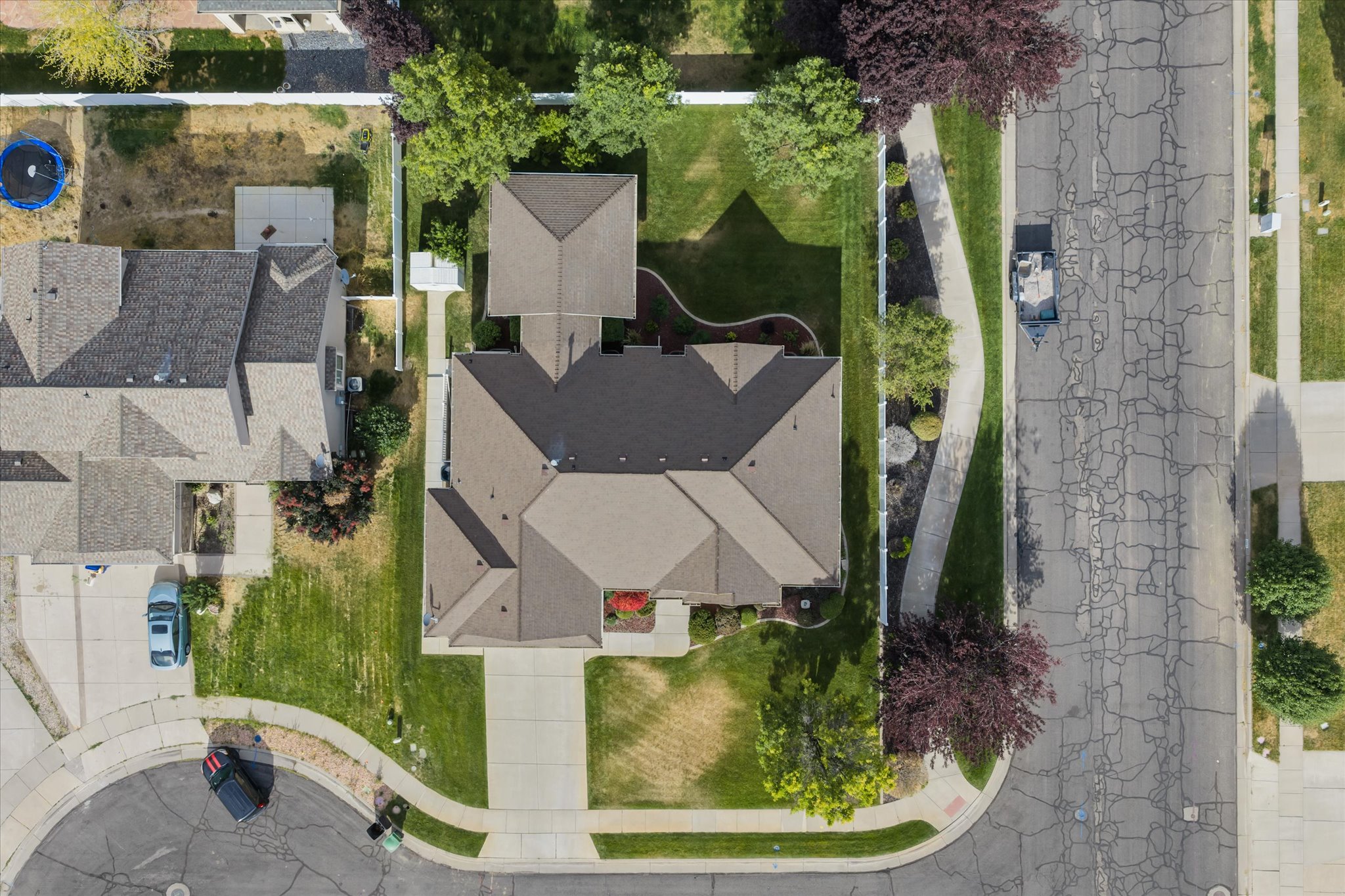 Property featuring a multi-gabled roofline, light brown shingles, and an attached two-car driveway