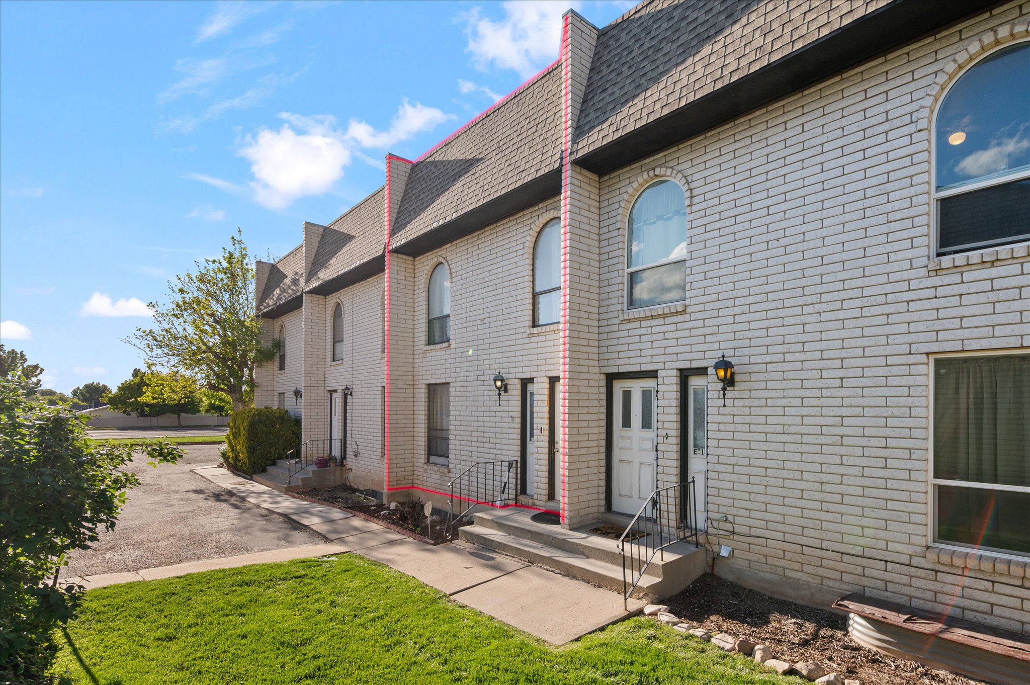 White brick exterior featuring arched windows