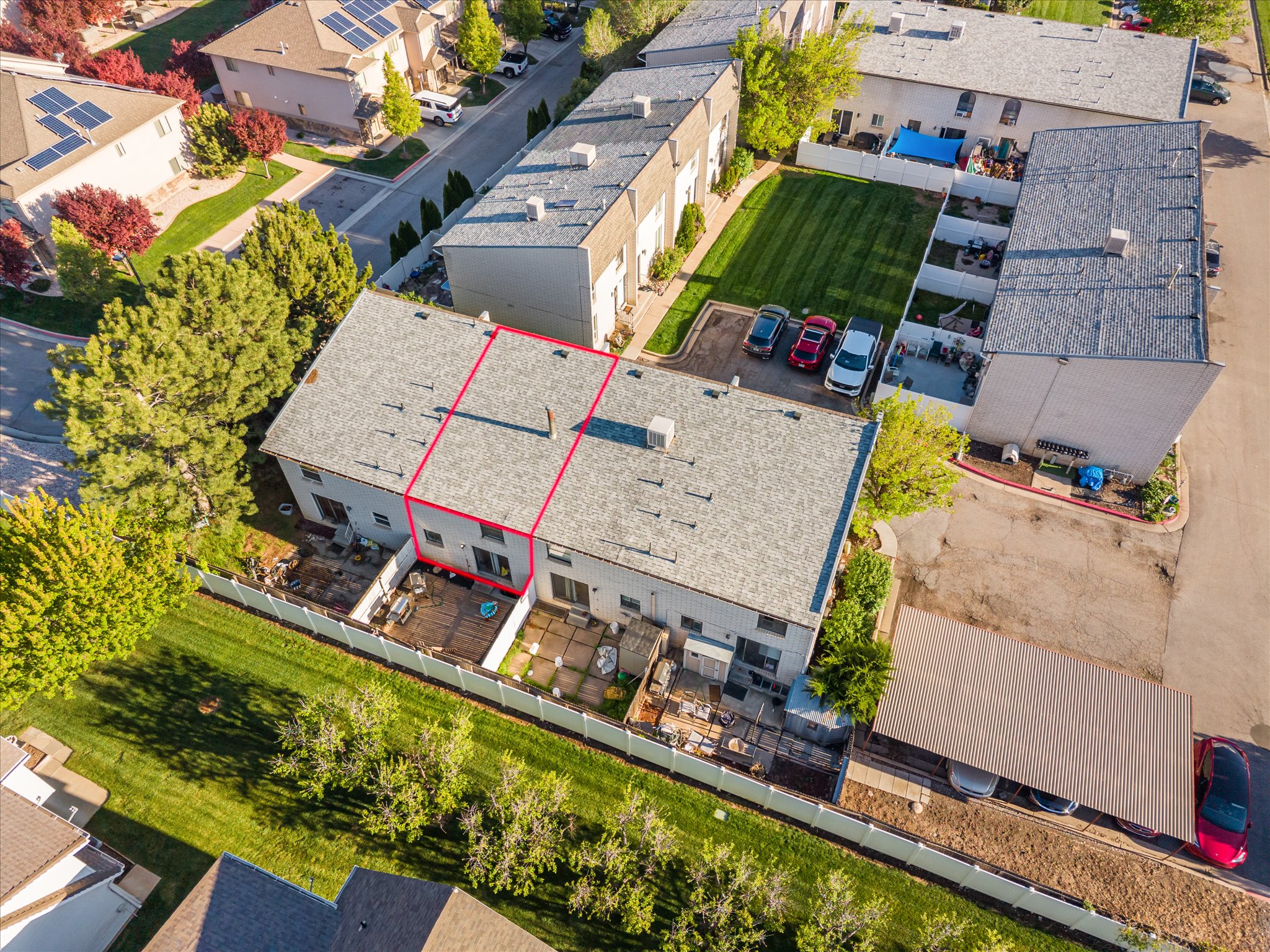 Aerial perspective showcasing a multi-unit property with a light grey roofing system