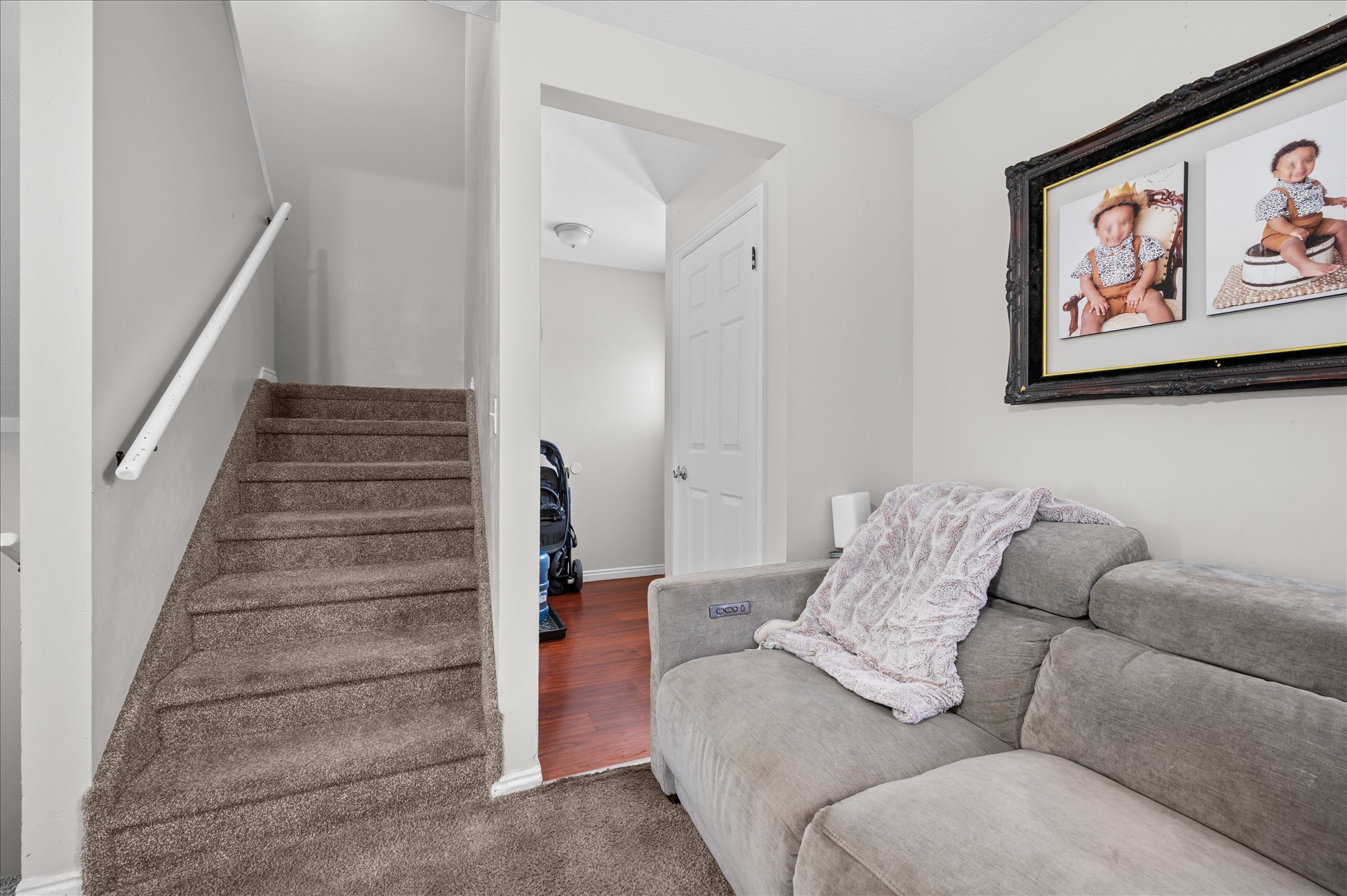 Carpeted staircase with white handrail leading to an upper level