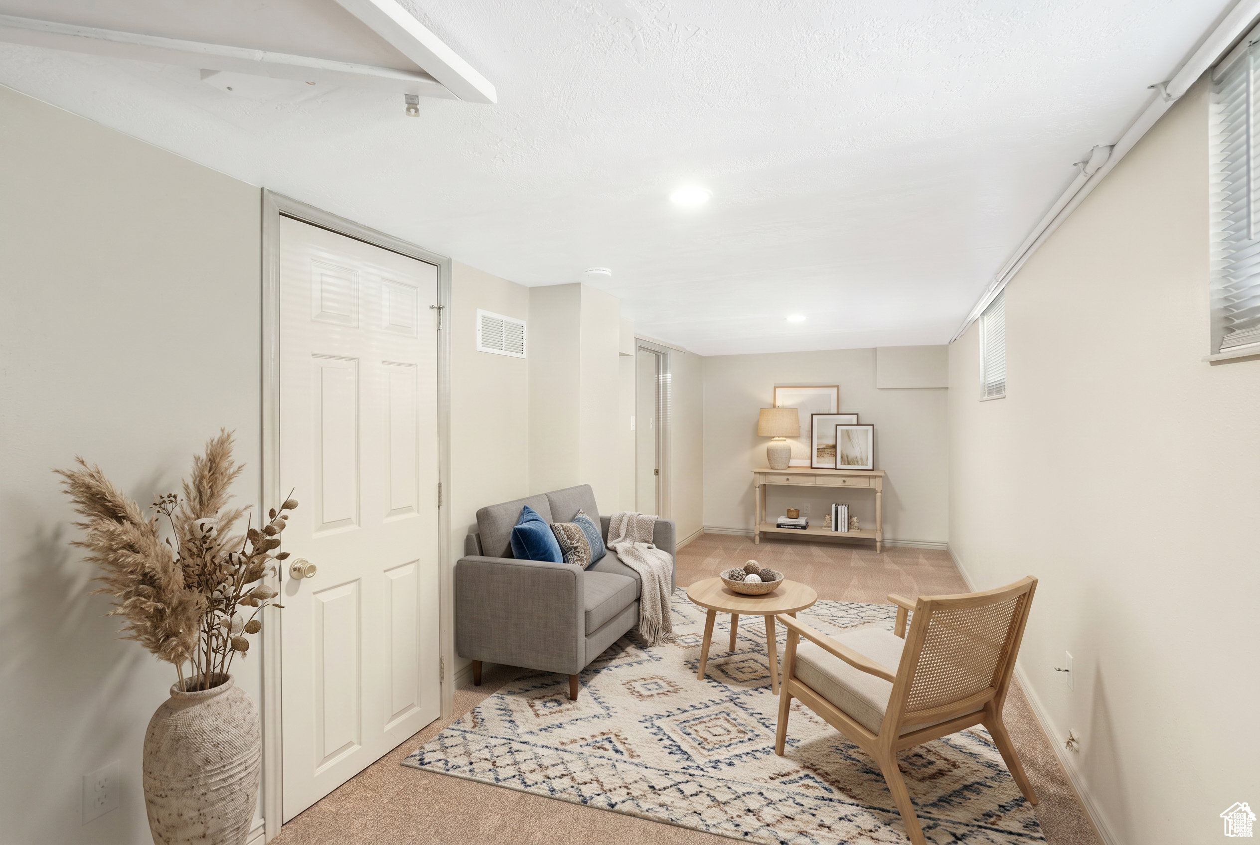 Carpeted lower-level room featuring recessed lighting, a window with blinds, and painted walls