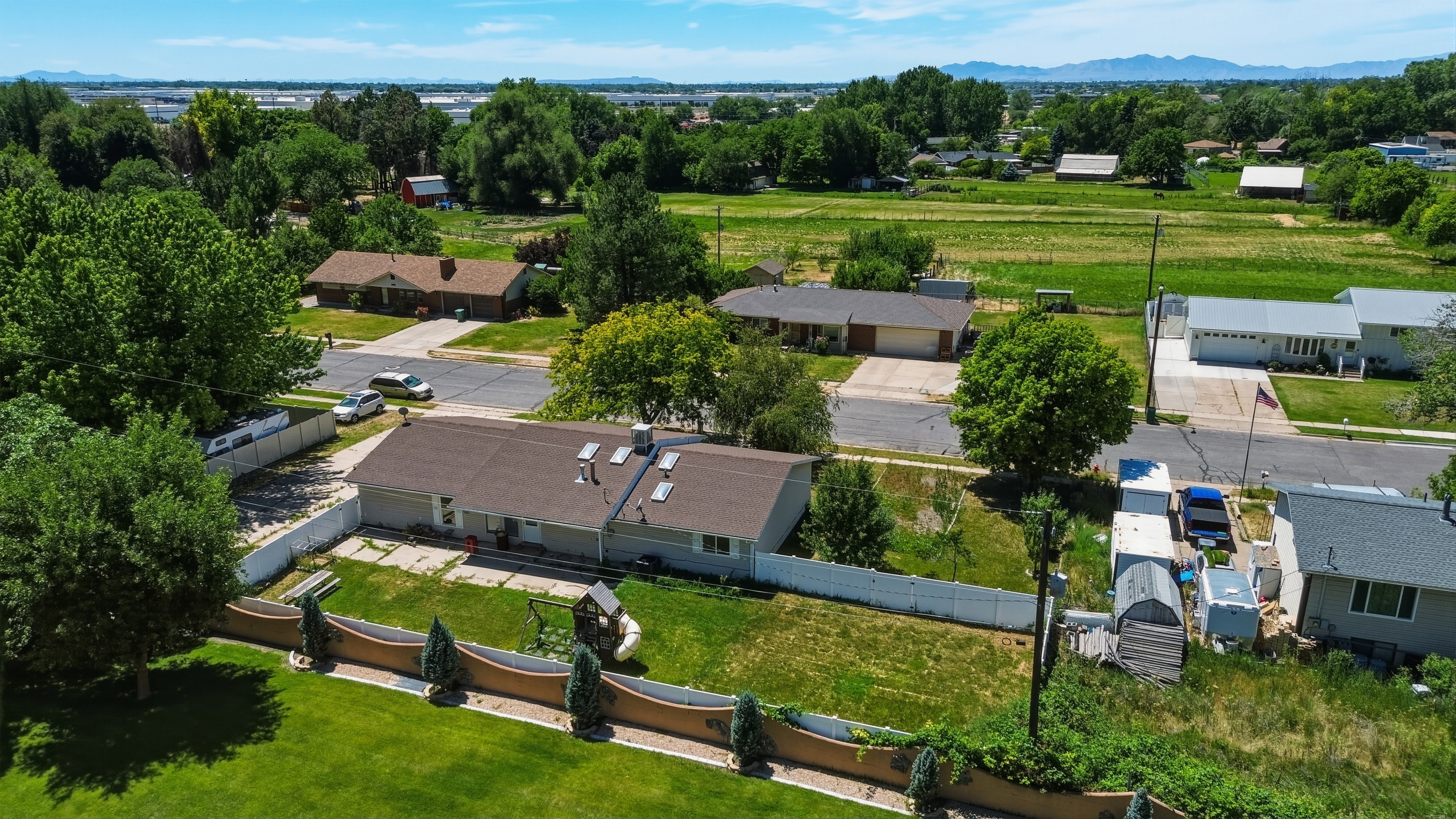 Aerial perspective showcasing a single-story residence with a brown shingle roof and multiple skylights