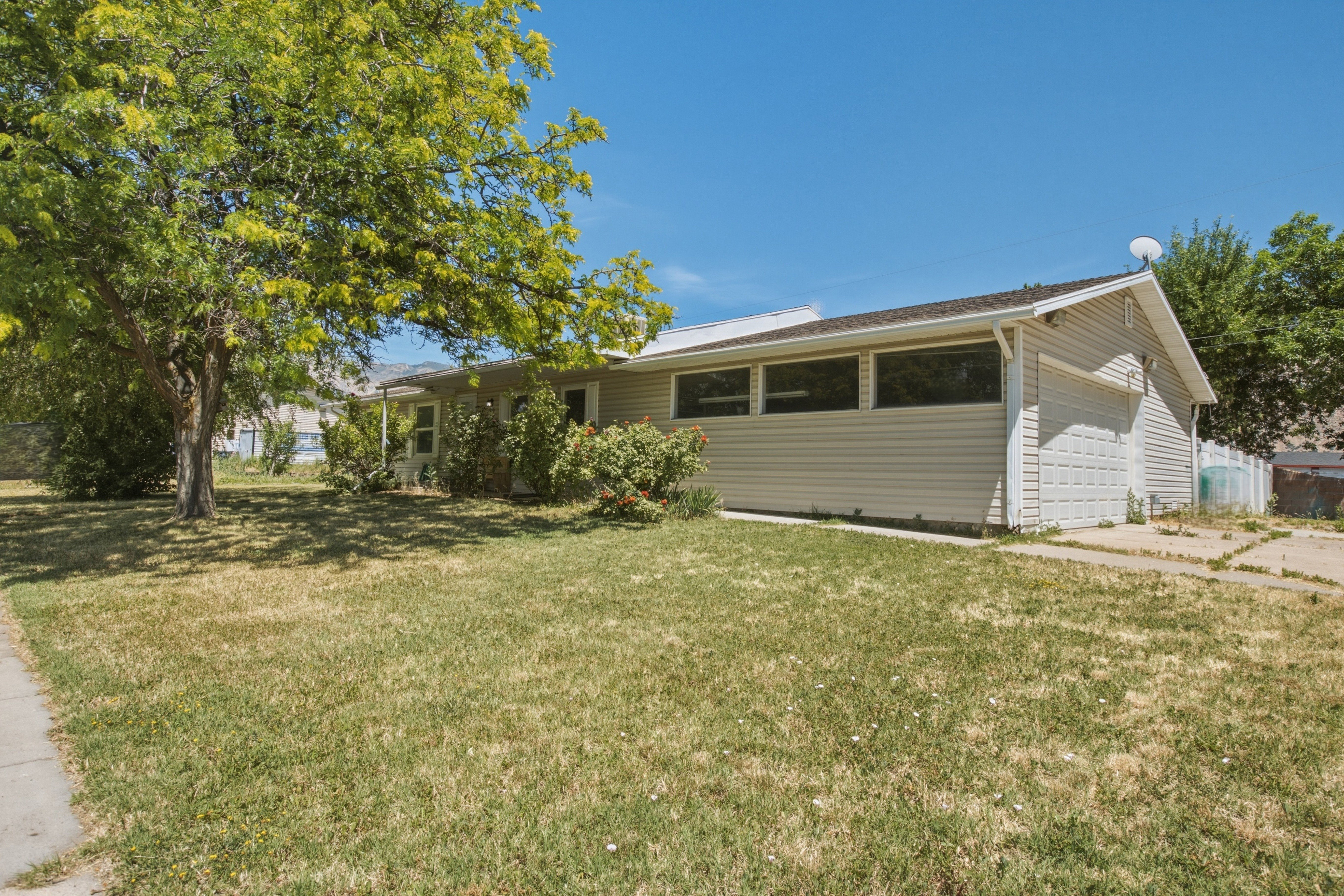 Ranch-style residence featuring horizontal siding, an attached garage, and a covered porch entry