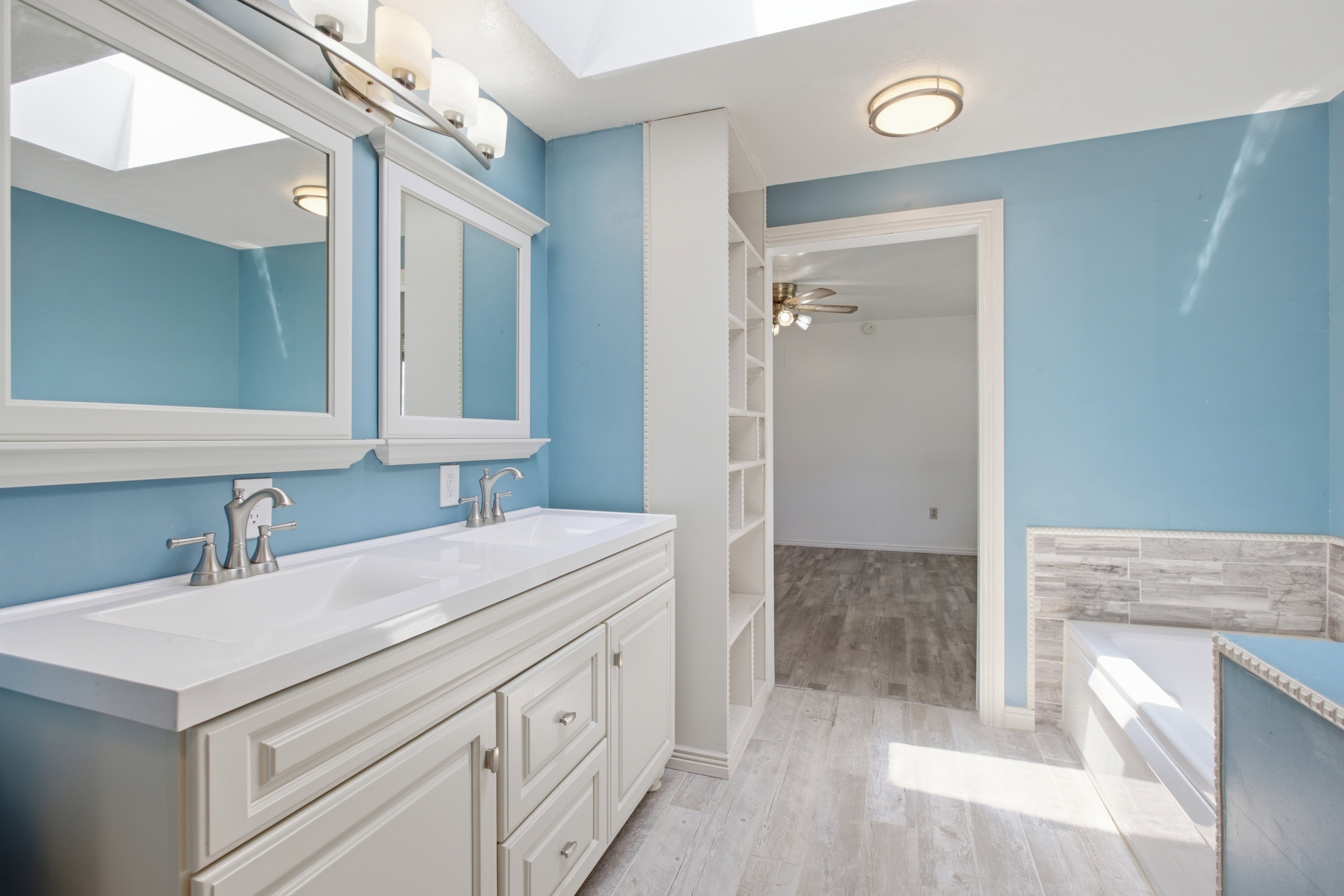 Bathroom featuring a dual vanity with white cabinetry, double rectangular sinks, and brushed nickel fixtures