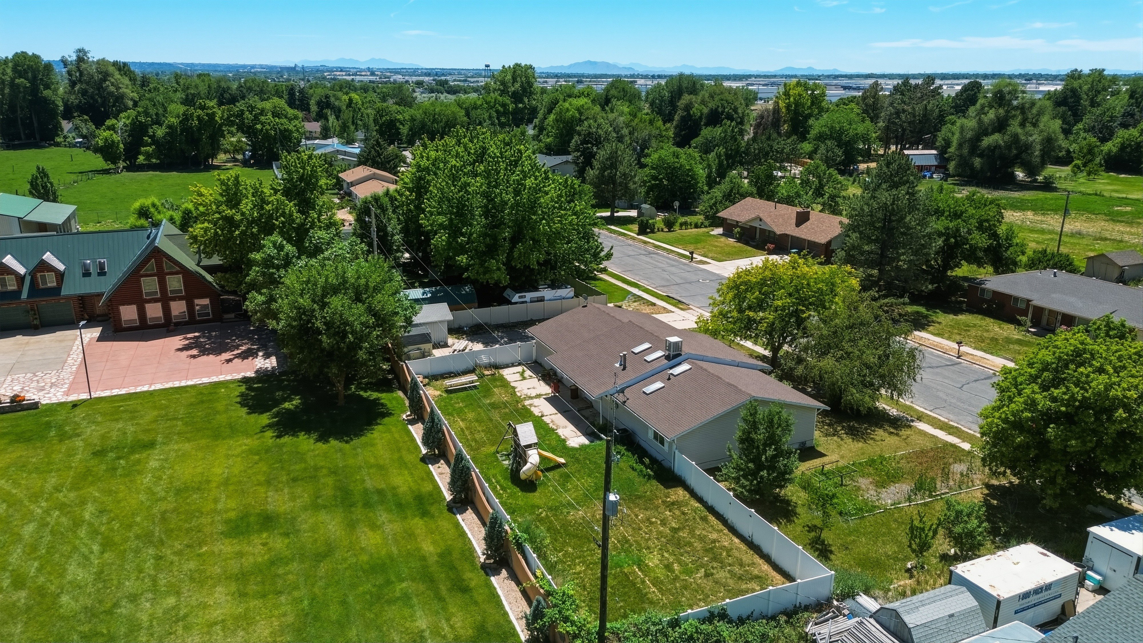Property features a large backyard with a white privacy fence and a manicured lawn