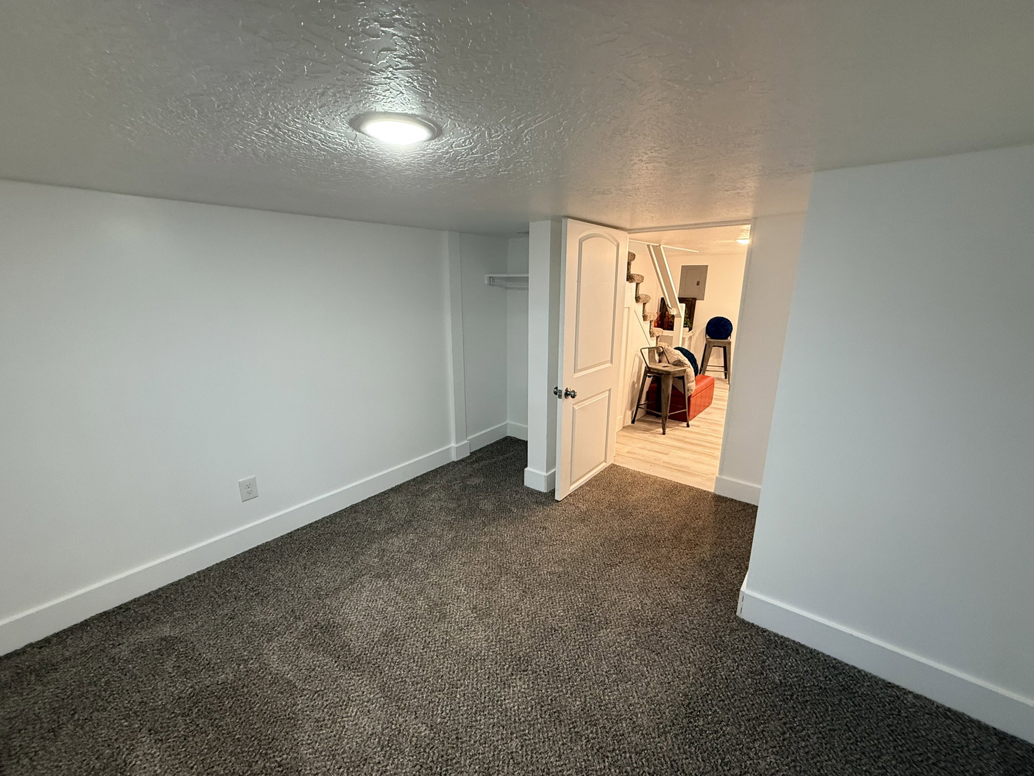 Carpeted room with white walls, recessed ceiling lighting, and white baseboards
