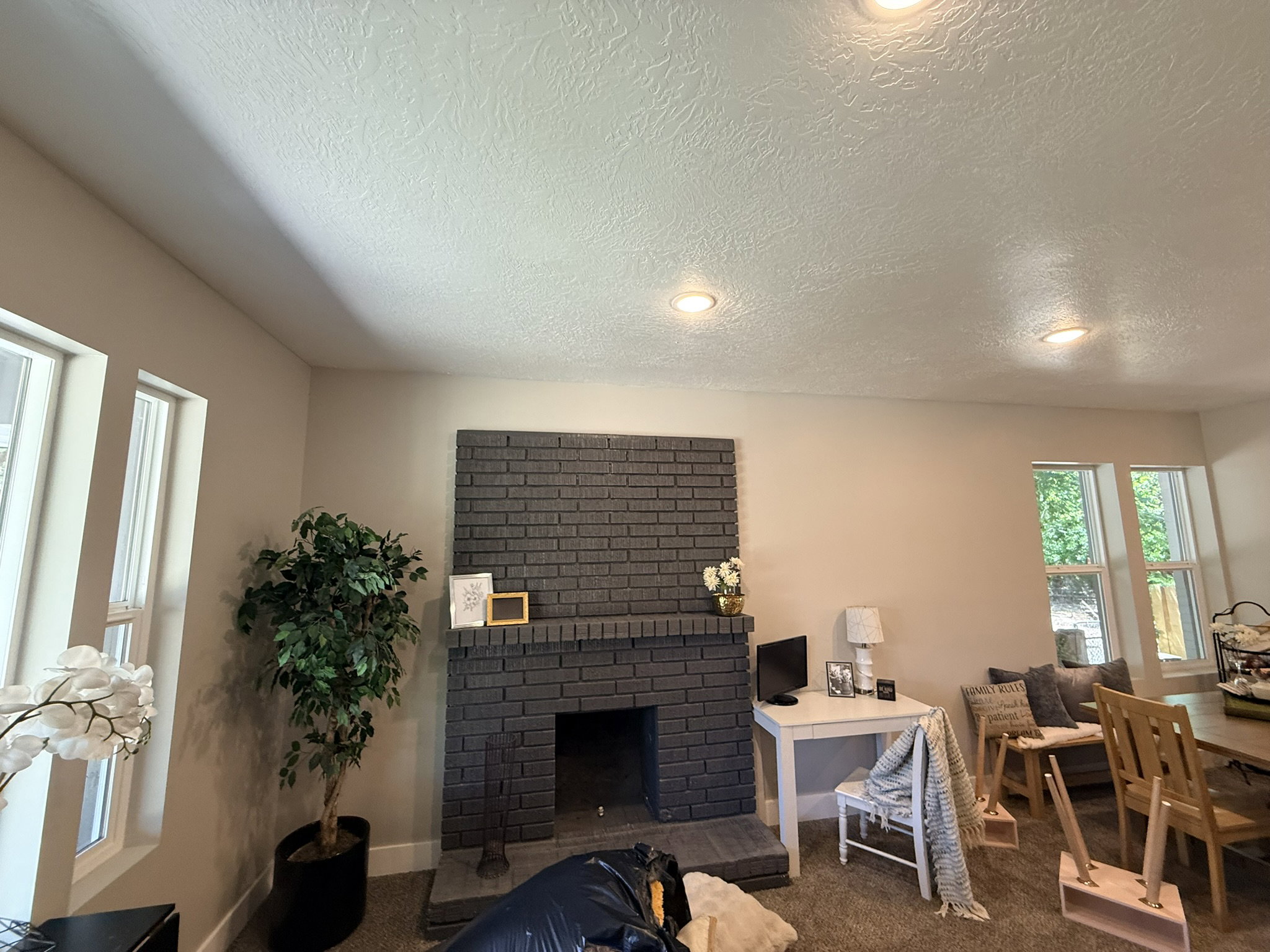 Living area featuring a painted brick fireplace with a hearth, recessed lighting, and multiple windows