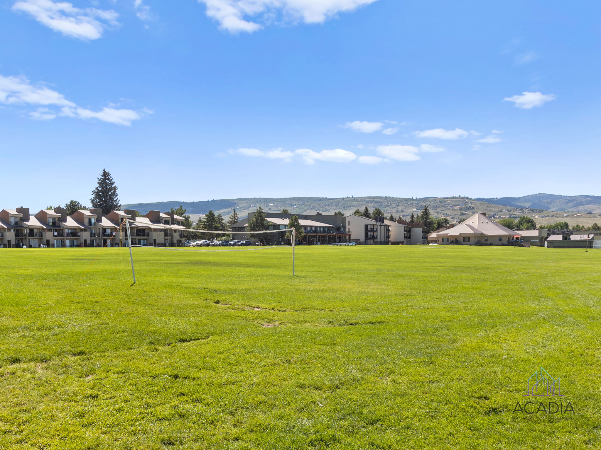 Expansive green space featuring a grass field and volleyball net