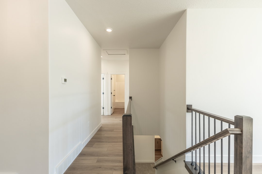 Hallway featuring wood-finish flooring, recessed lighting, and a modern thermostat