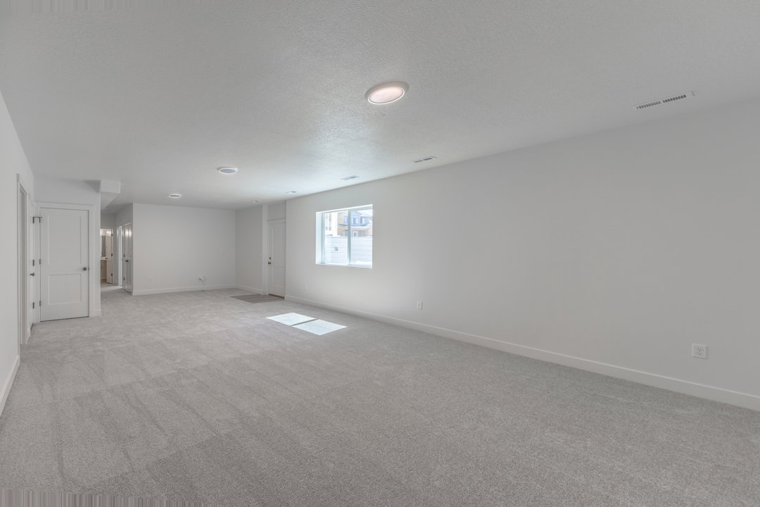 Spacious room featuring neutral carpeting and white walls