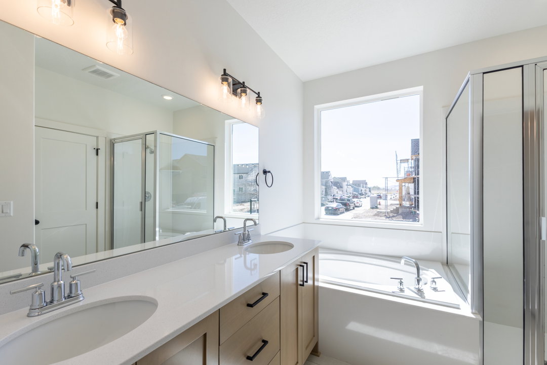 Dual vanity featuring light wood-finish cabinetry, white countertops, and undermount sinks