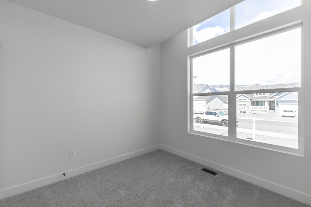Room featuring high ceilings, light gray carpeting, and white walls