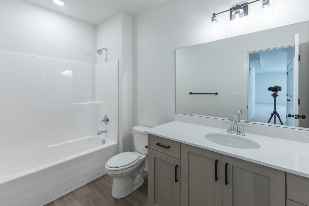 Bathroom featuring a single vanity with light-toned wood-finish cabinetry, a white countertop, and an undermount sink