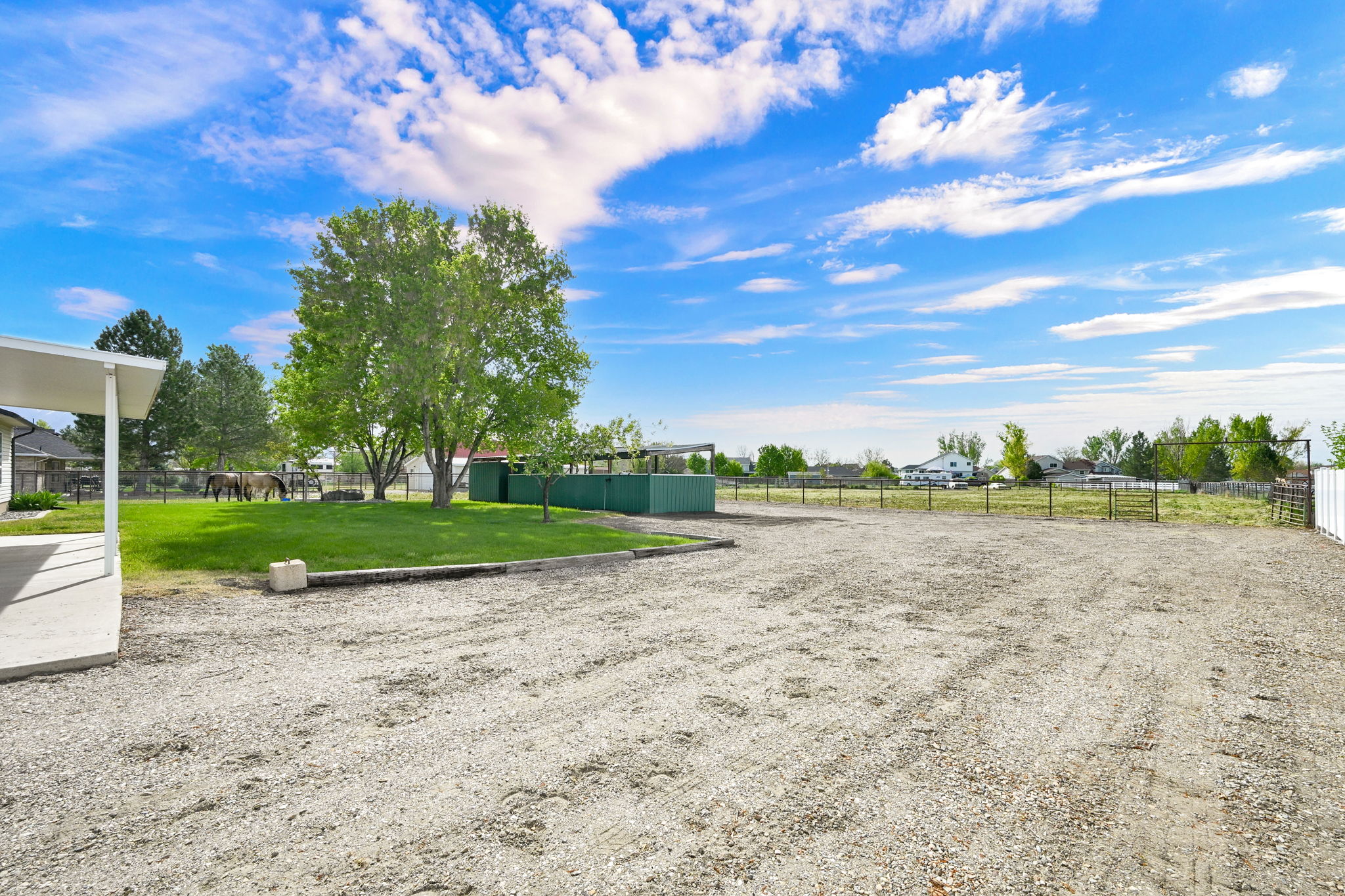Expansive gravel parking area with a covered patio