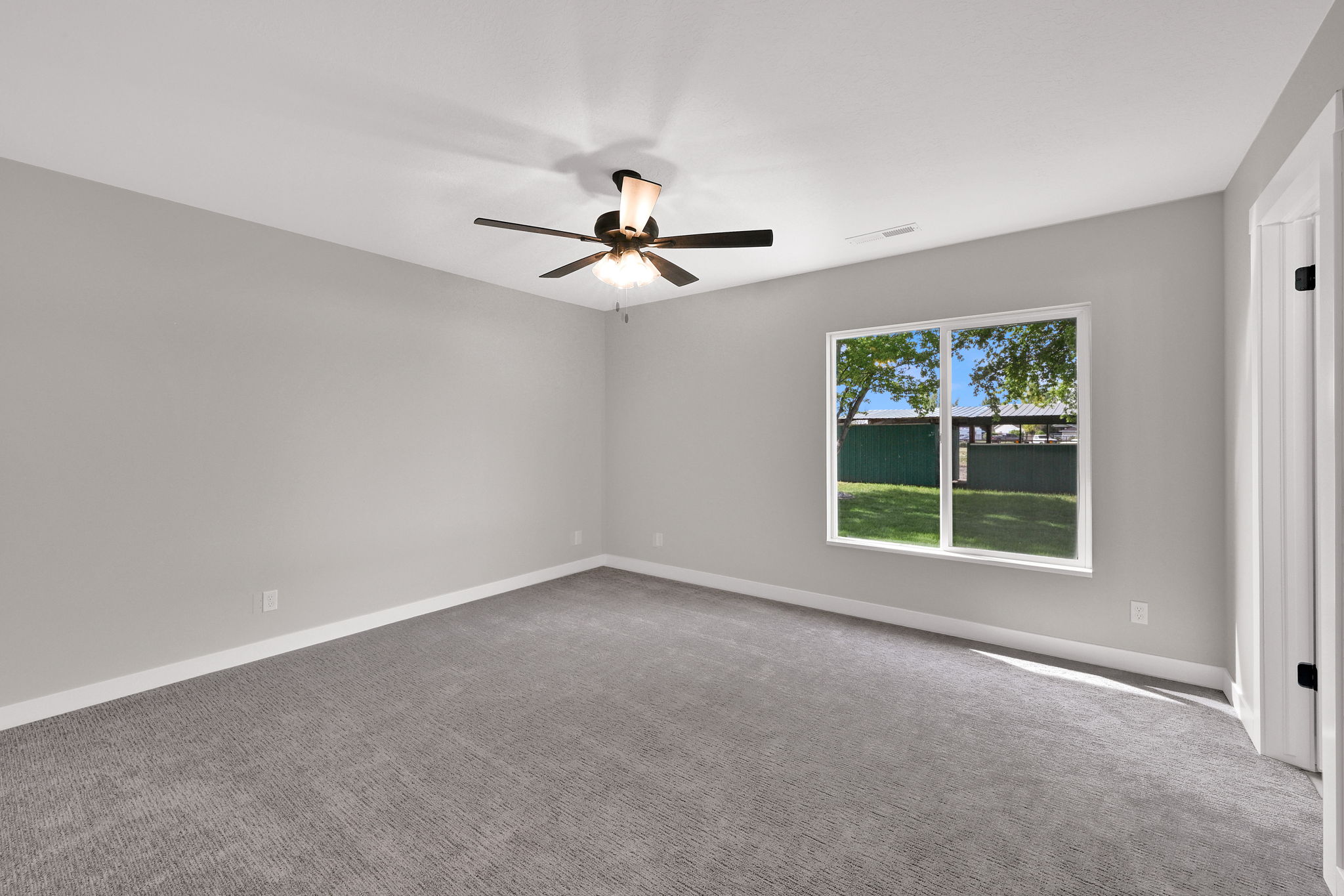 Spacious room featuring neutral carpeting and light gray walls