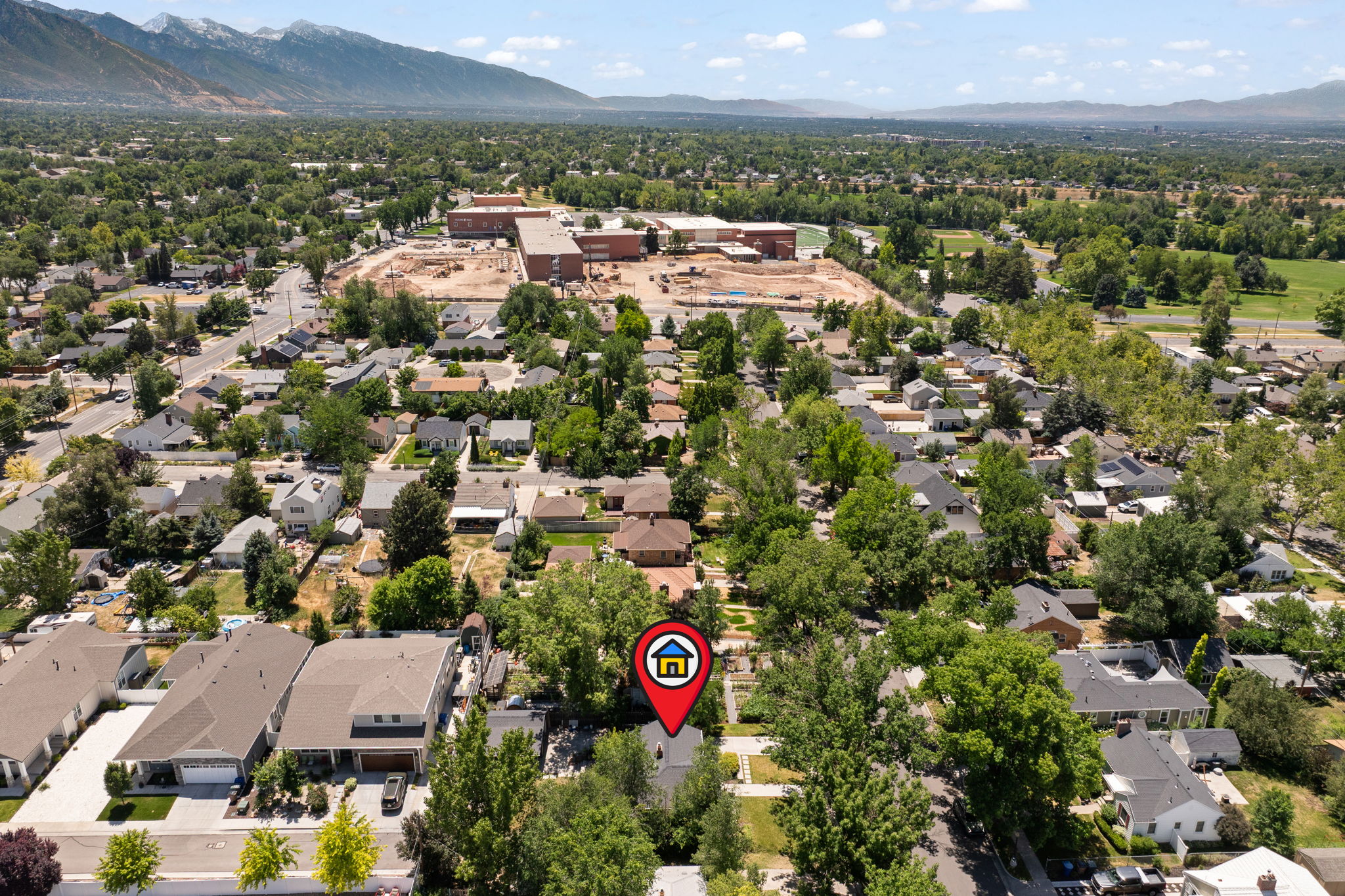 Residential neighborhood with mature trees and mountain scenery