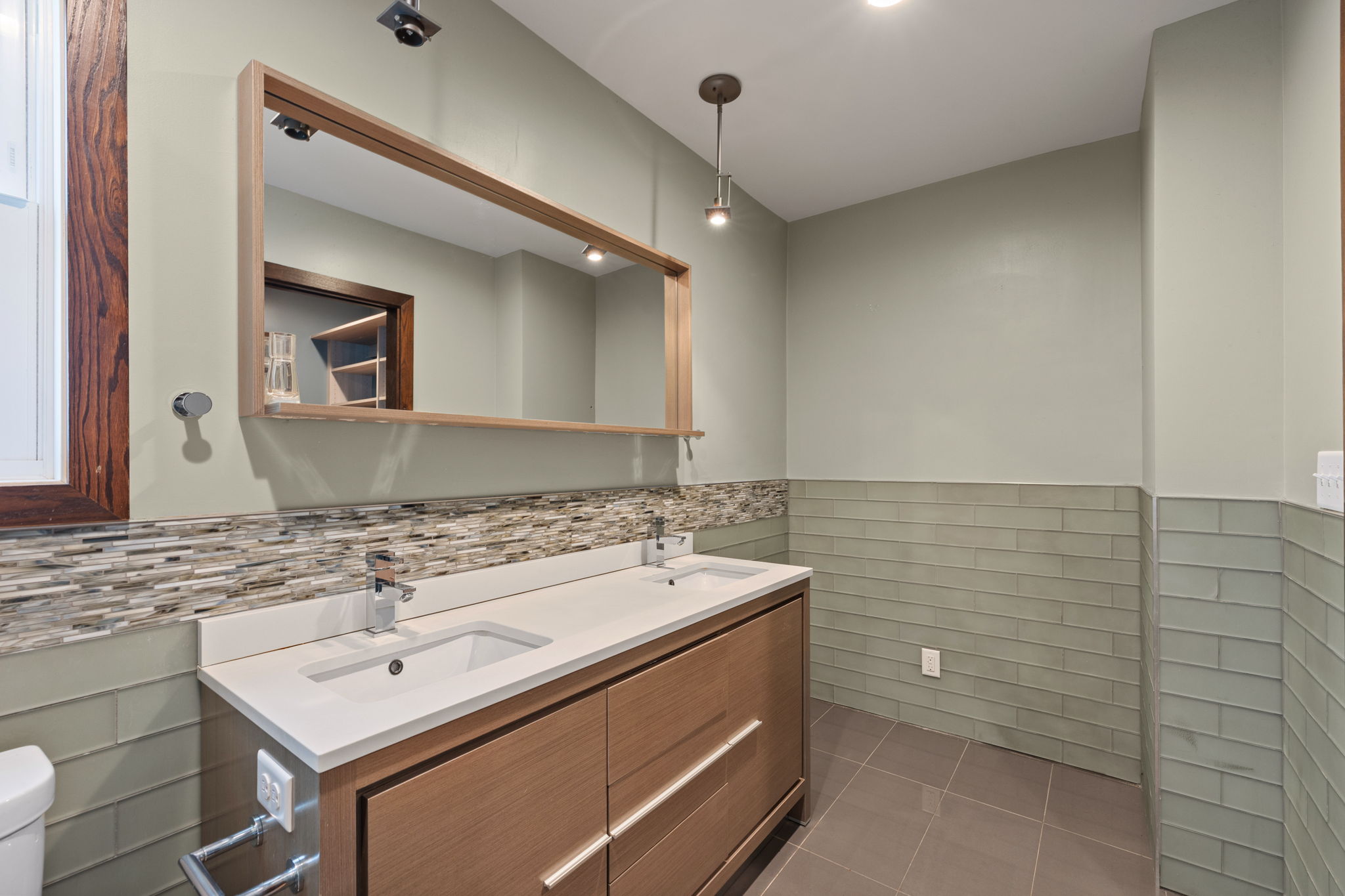 Double vanity with integrated sinks, white countertops, and chrome fixtures