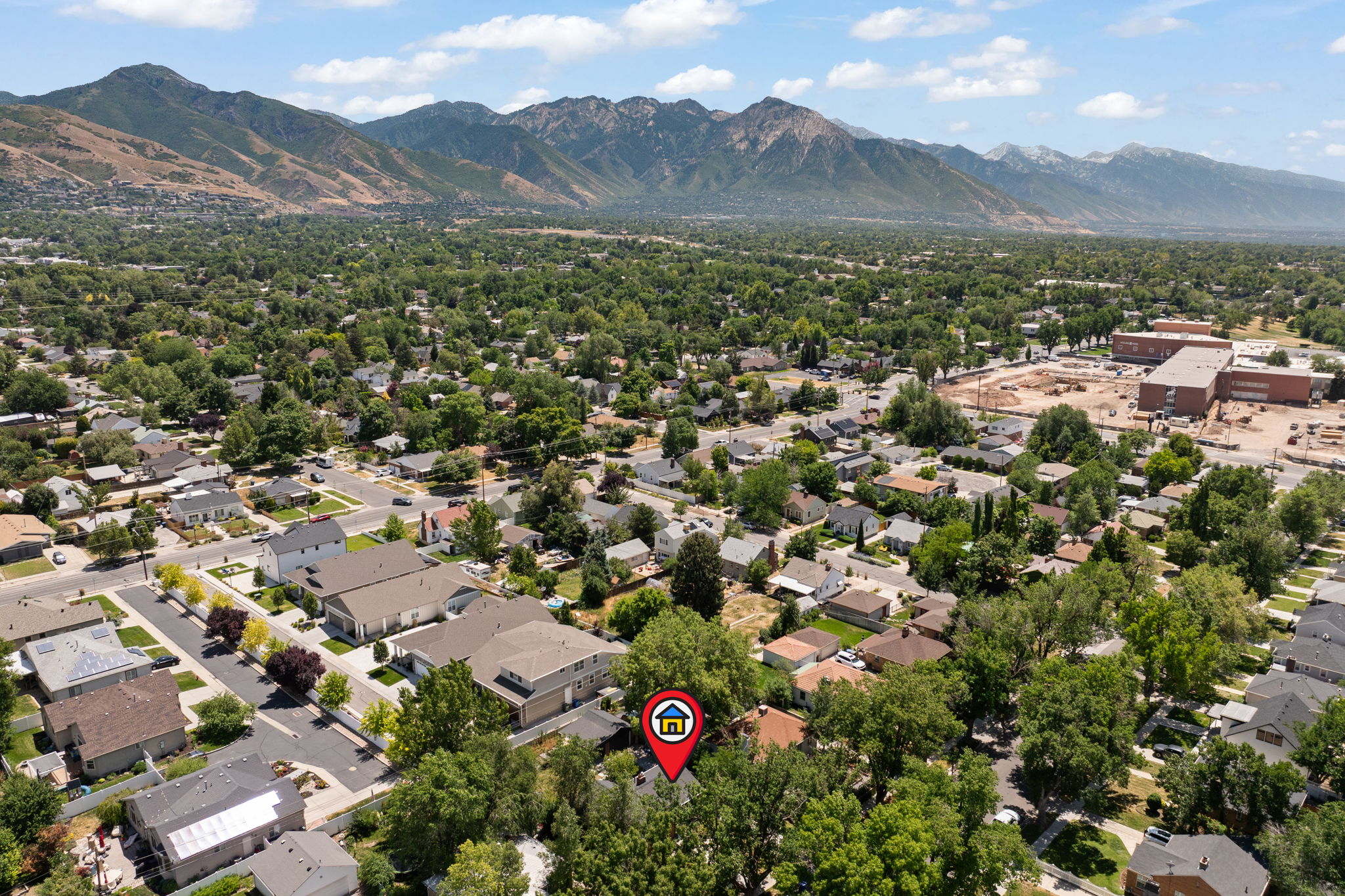 Expansive residential area with dense tree cover and mountain backdrops