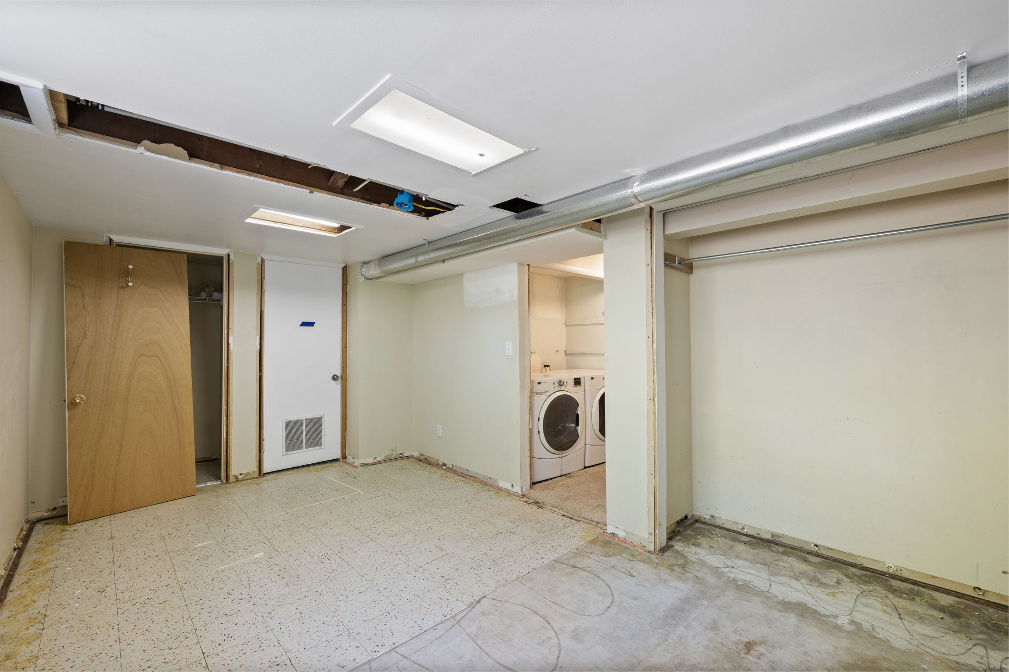 Utility space featuring a laundry area with appliances, exposed ceiling joists, and a metal duct system