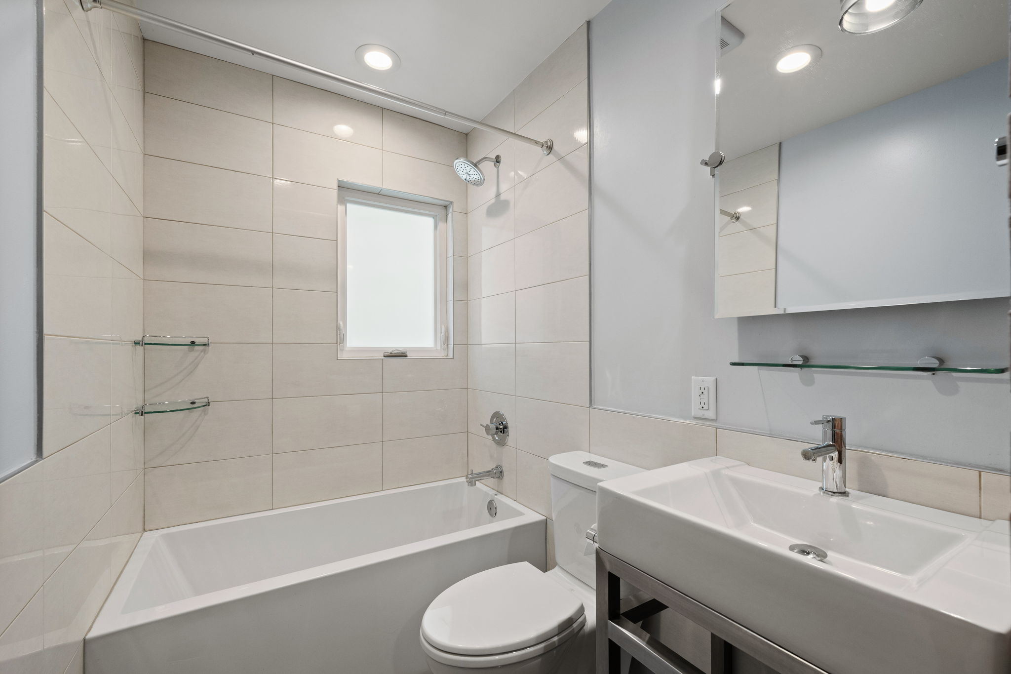 Bathroom featuring a wall-mounted vanity with a rectangular basin sink, chrome faucet, and mirrored medicine cabinet