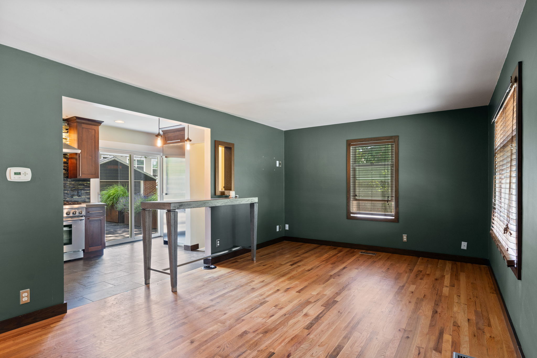 Spacious room with wood-finish flooring and deep green walls