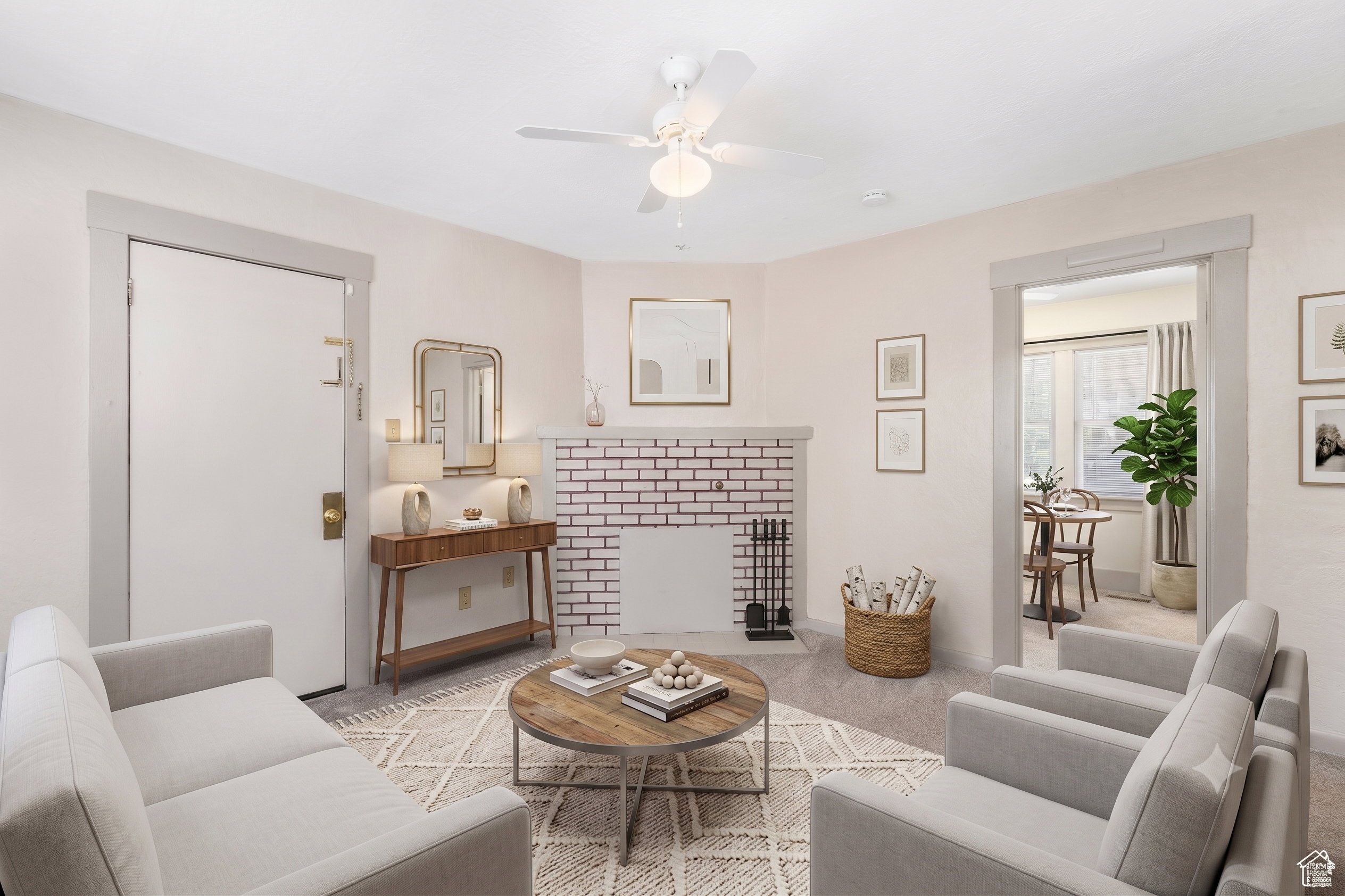 Living space featuring light-toned wall finishes, carpet flooring, a ceiling fan, and an exposed brick fireplace