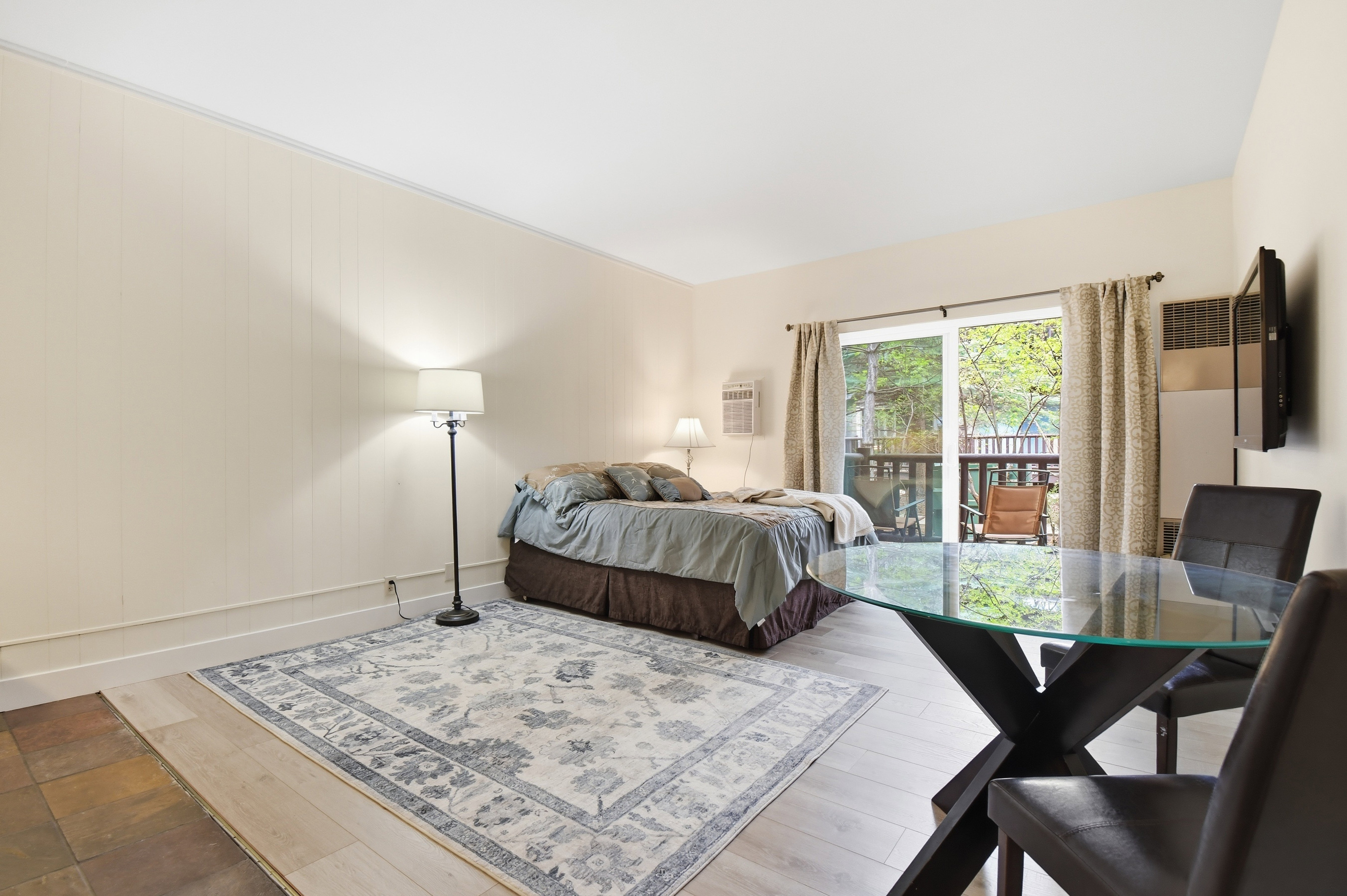 Light-toned interior with mixed flooring including wood-finish planks and stone-look tiles