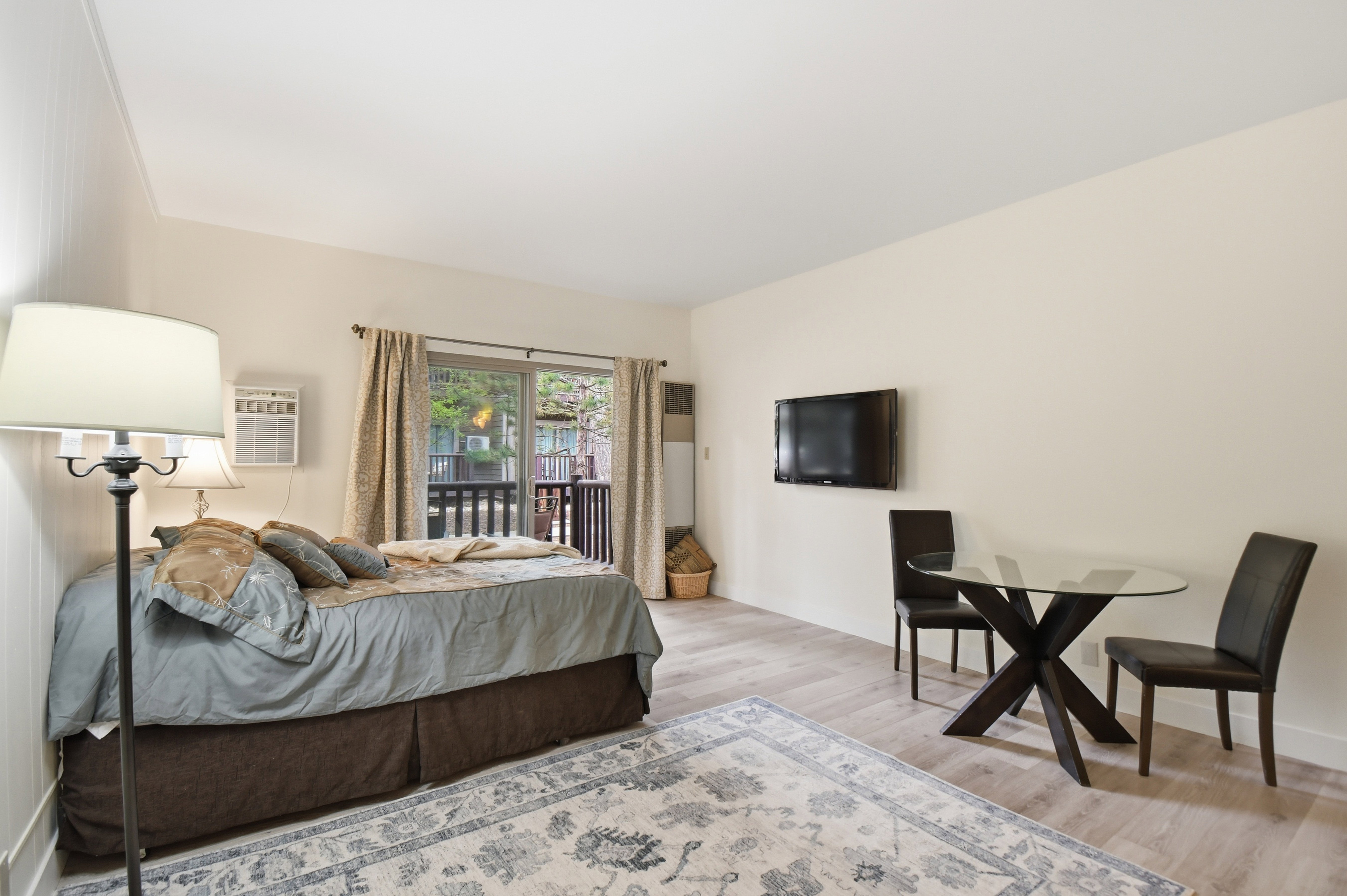 Open-concept living space with light-colored walls and wood-finish flooring