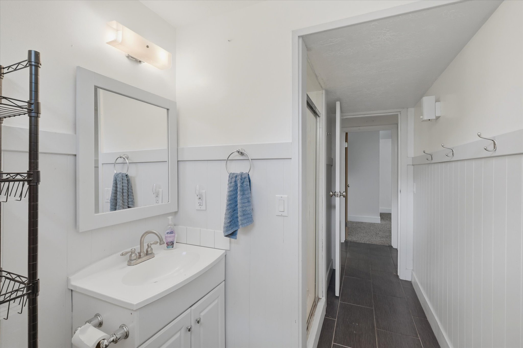 Bathroom featuring a white vanity with a single basin, brushed nickel faucet, and framed mirror