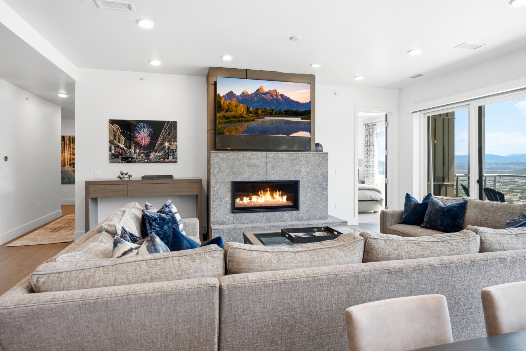 Living area featuring a modern fireplace with stone surround, recessed lighting, wood-finish flooring, and sliding glass doors opening to outdoor space