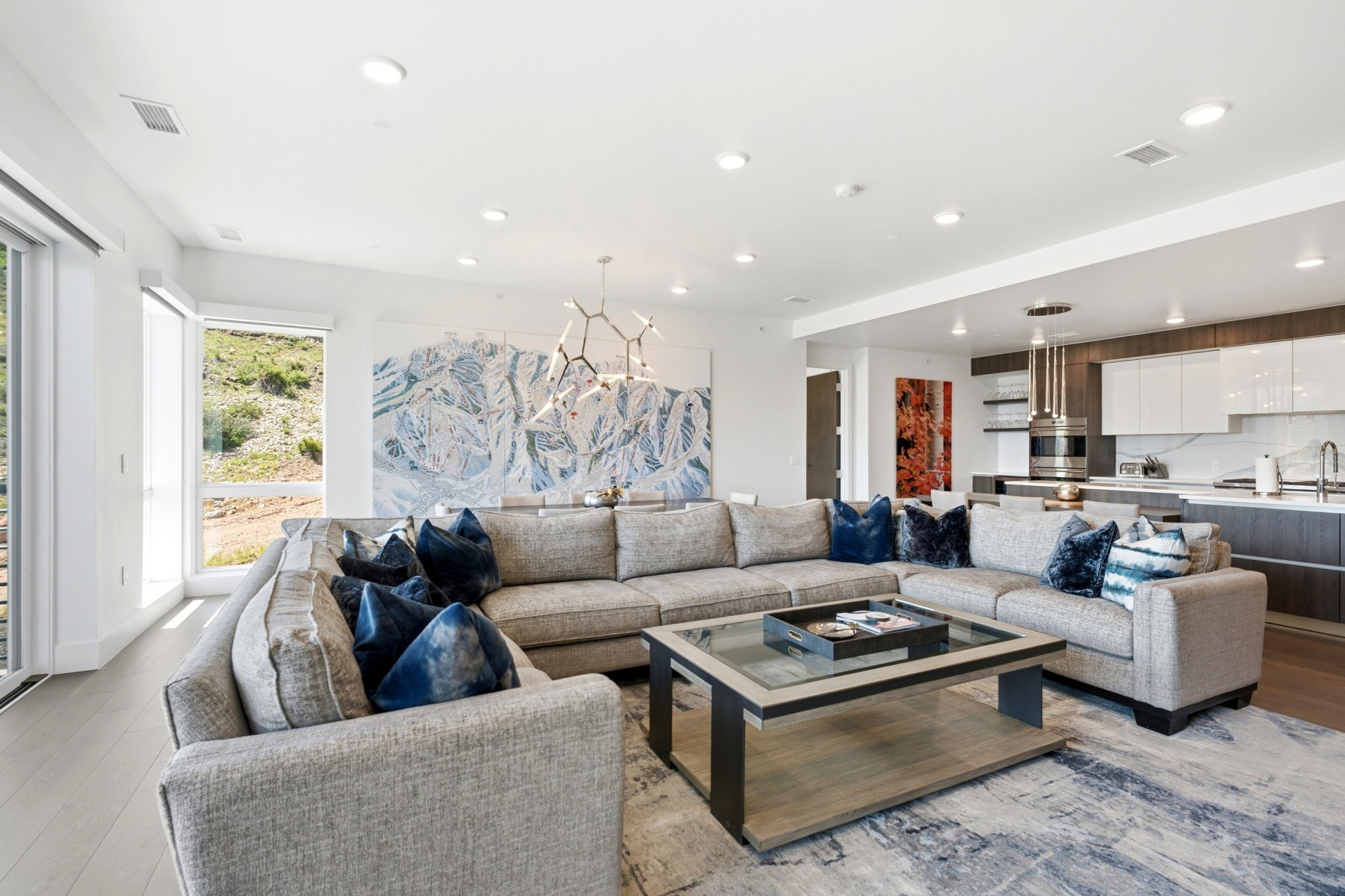 Open-concept living space featuring wood-finish flooring, recessed lighting, and large windows